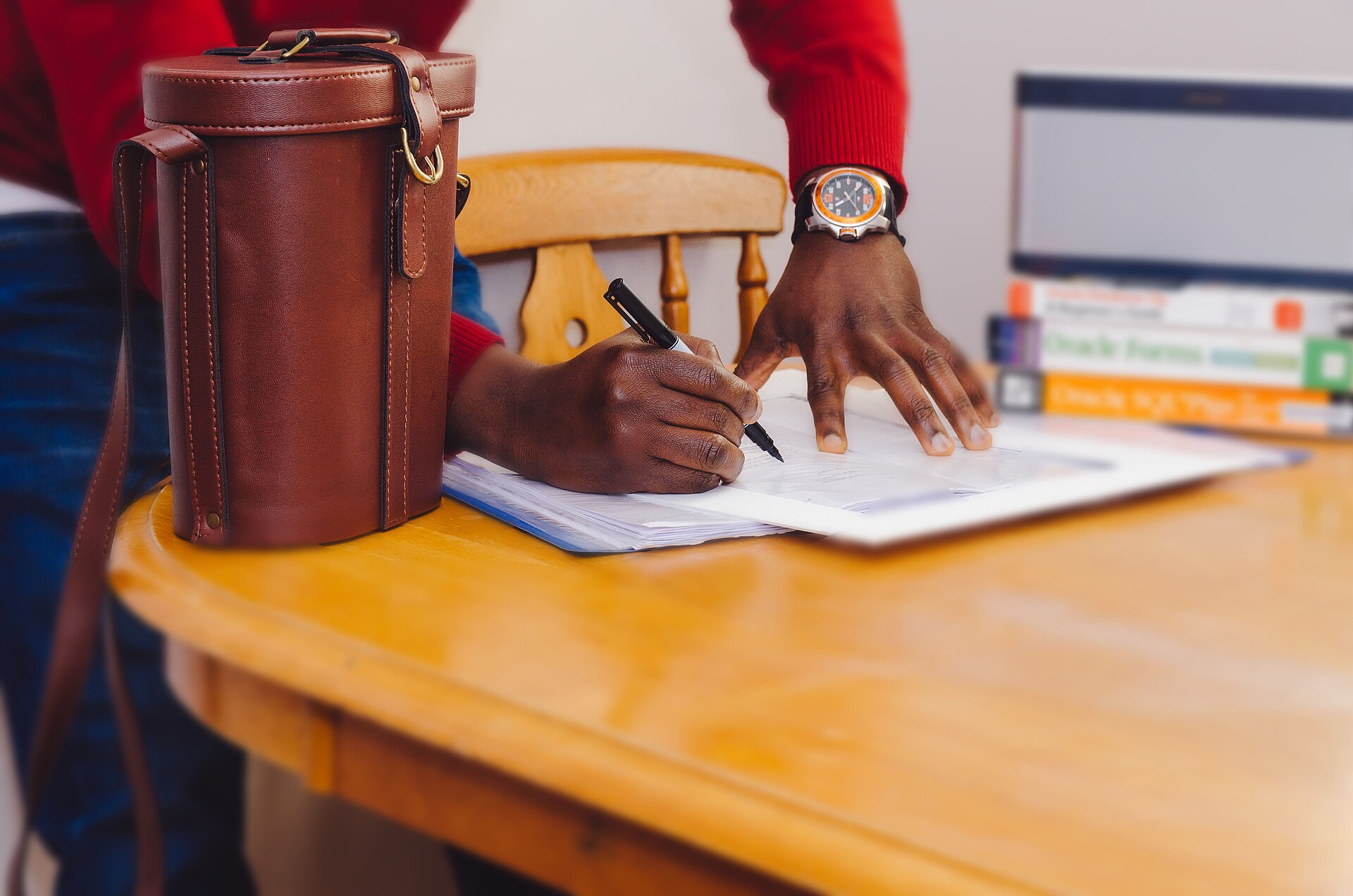 A person writing notes with a pen on paper at a desk