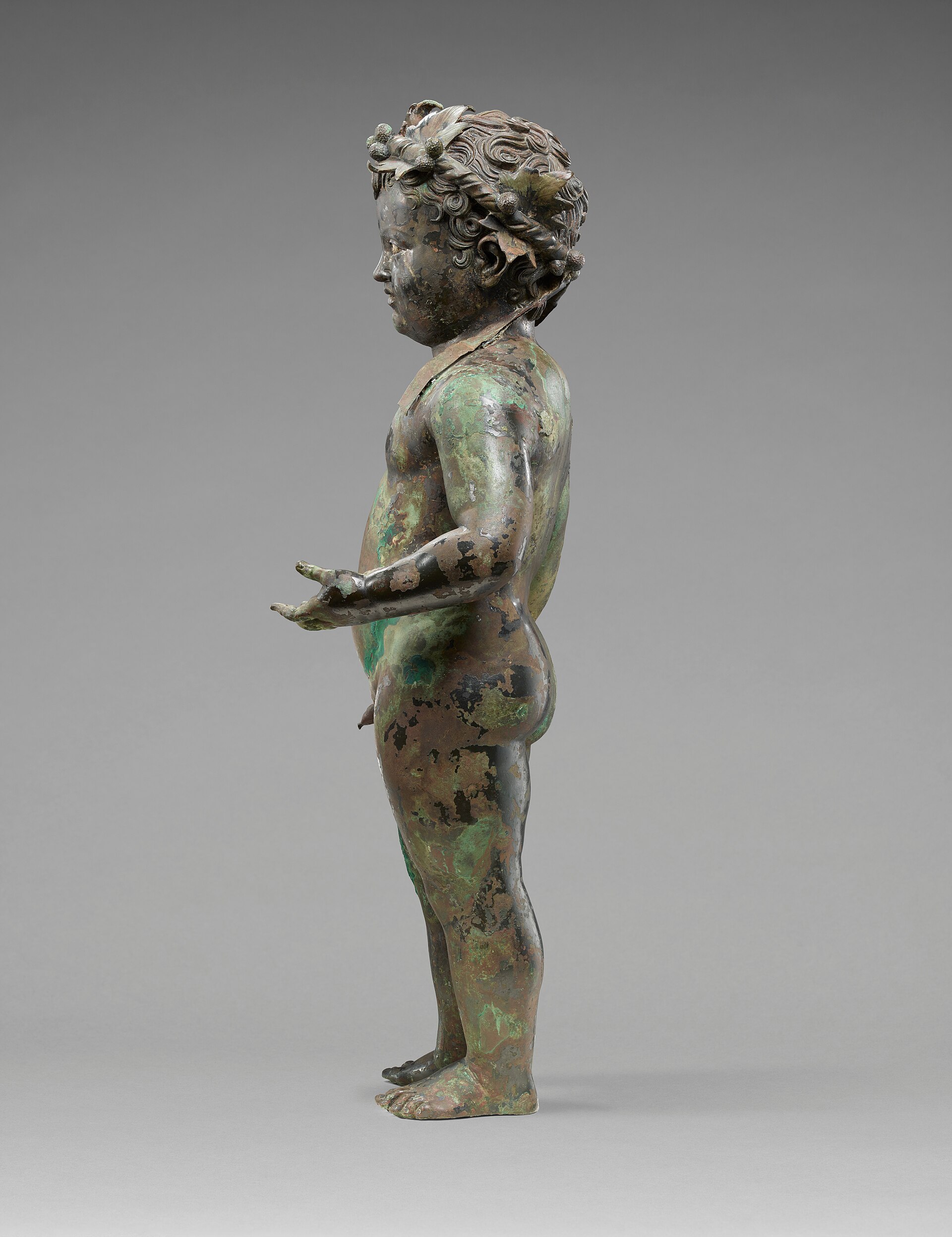 Ancient Roman bronze statue of an infant drinking