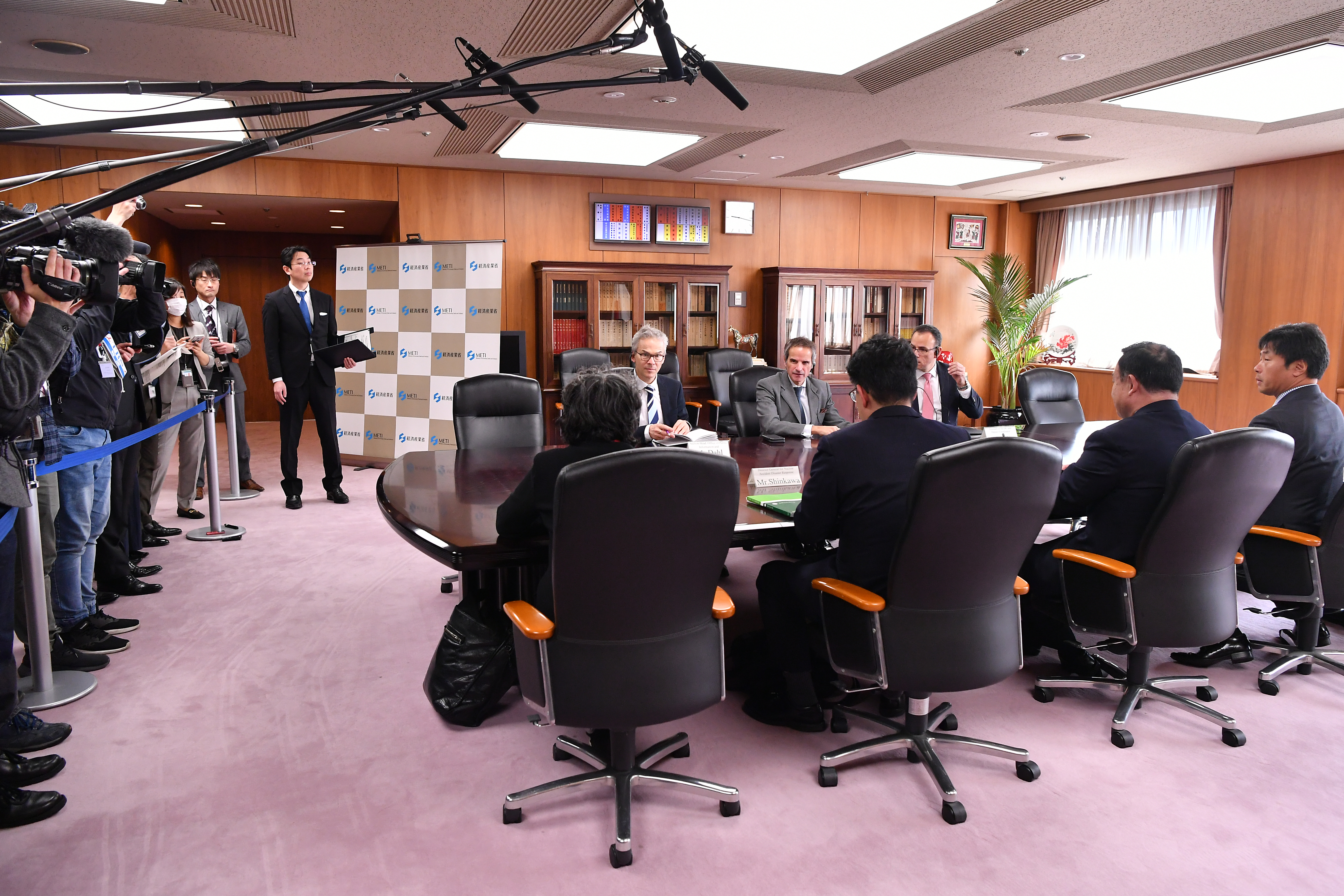 A formal meeting with officials seated around a conference table
