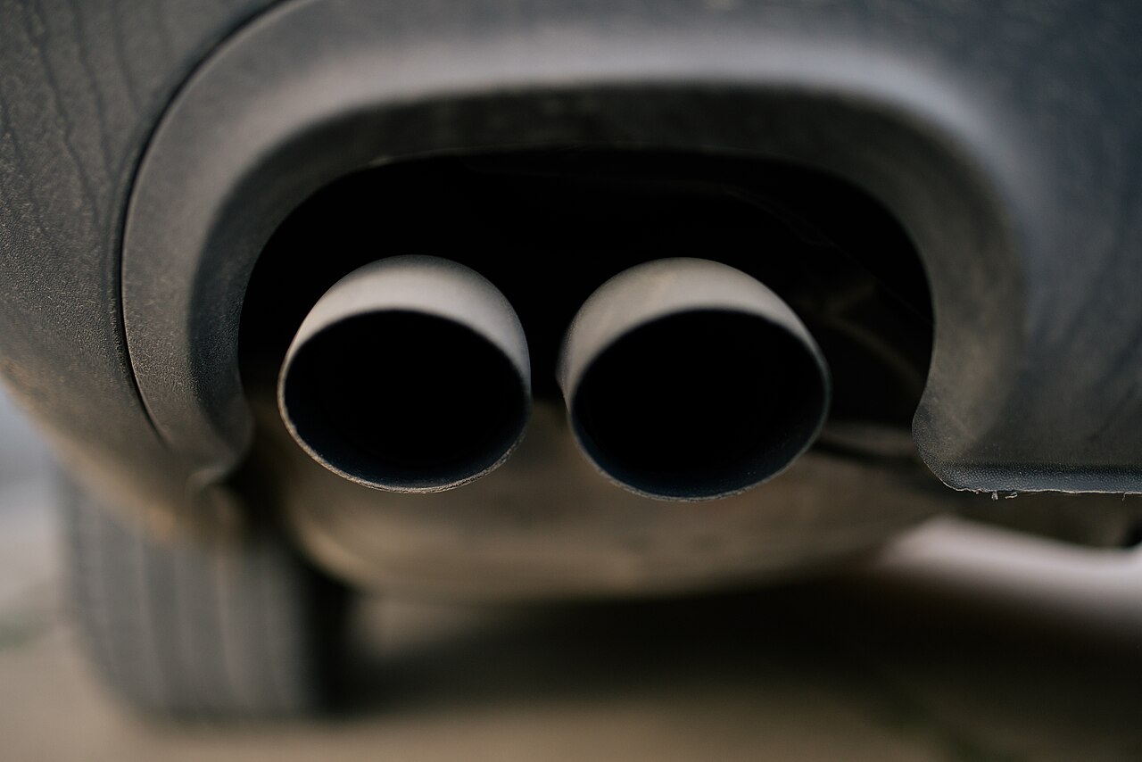 A close-up of a car exhaust pipe where treated gases exit the tailpipe