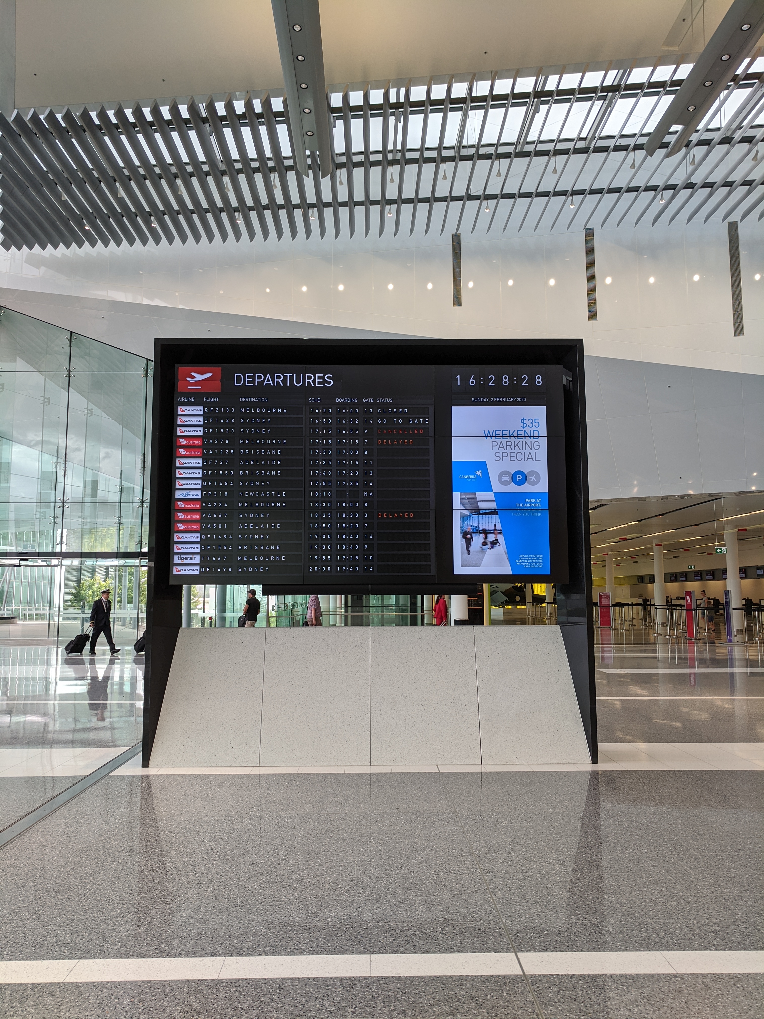 Departure boards at a busy international airport terminal