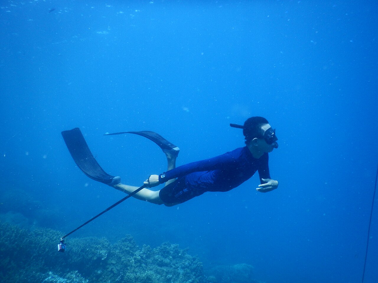 A freediver descending along a line in open water