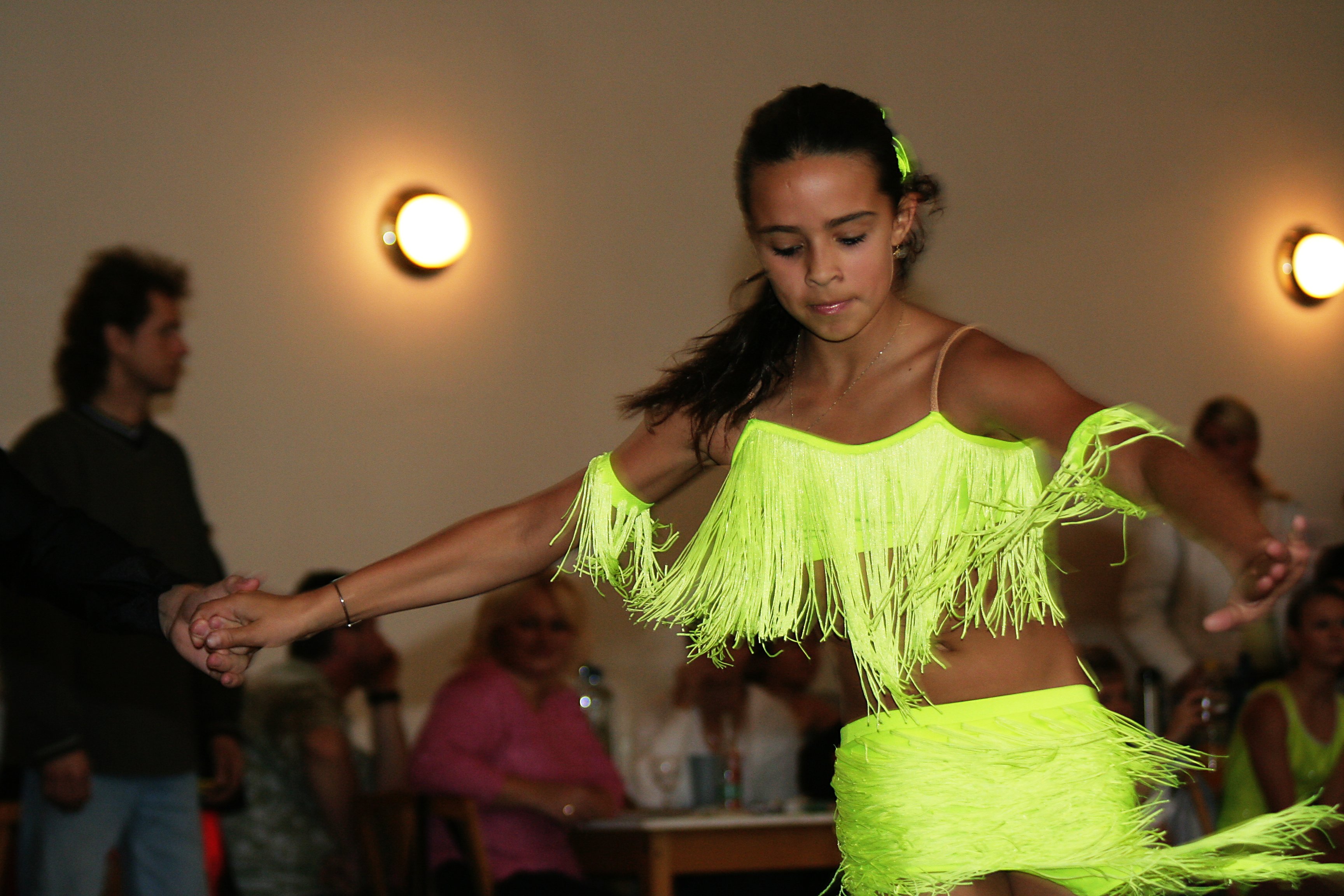 Ballroom dancers compete under bright stage lights