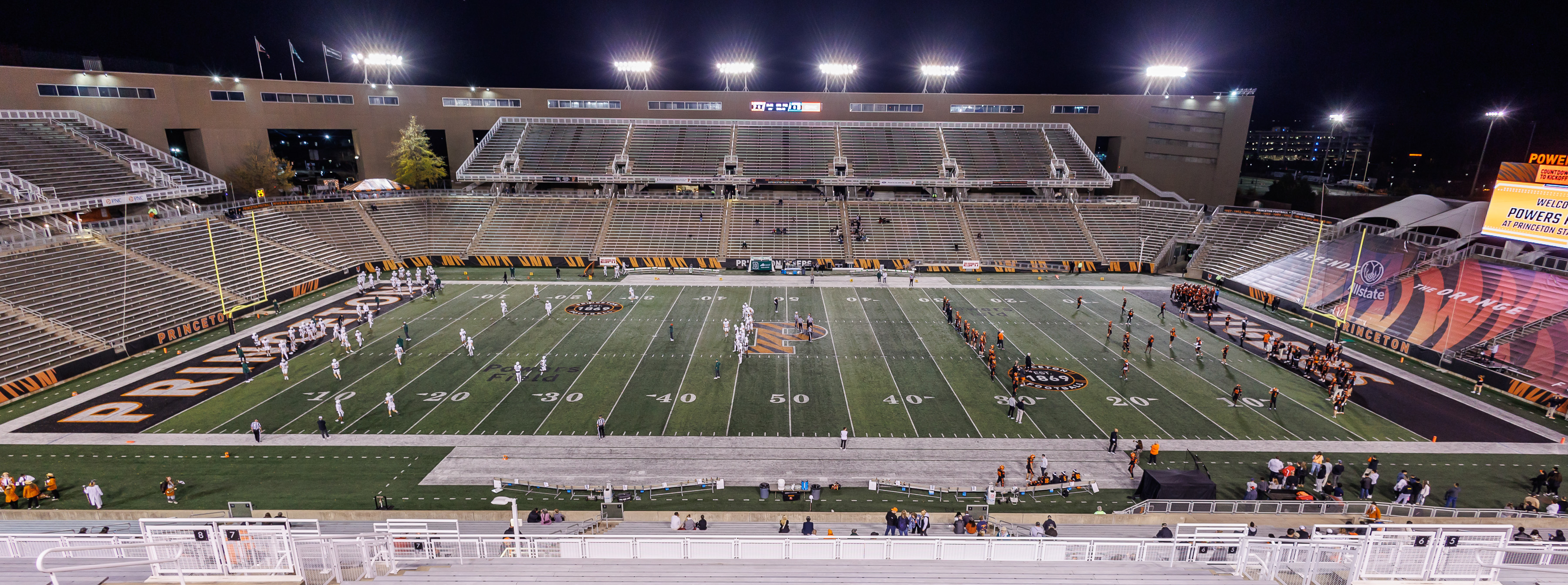 A football stadium glows at night during a game
