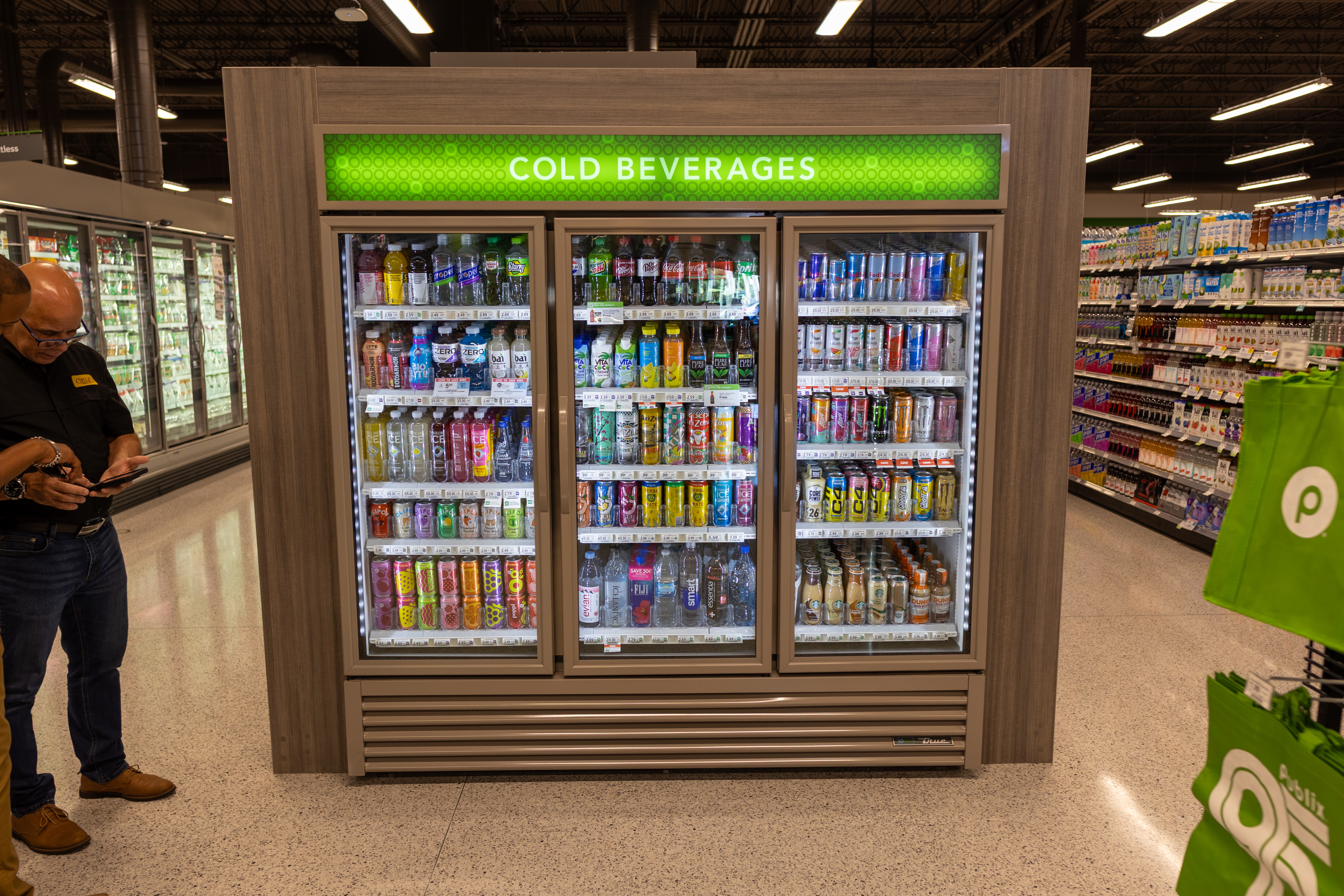 Long rows of glass-door refrigerators stocked with drinks inside a supermarket