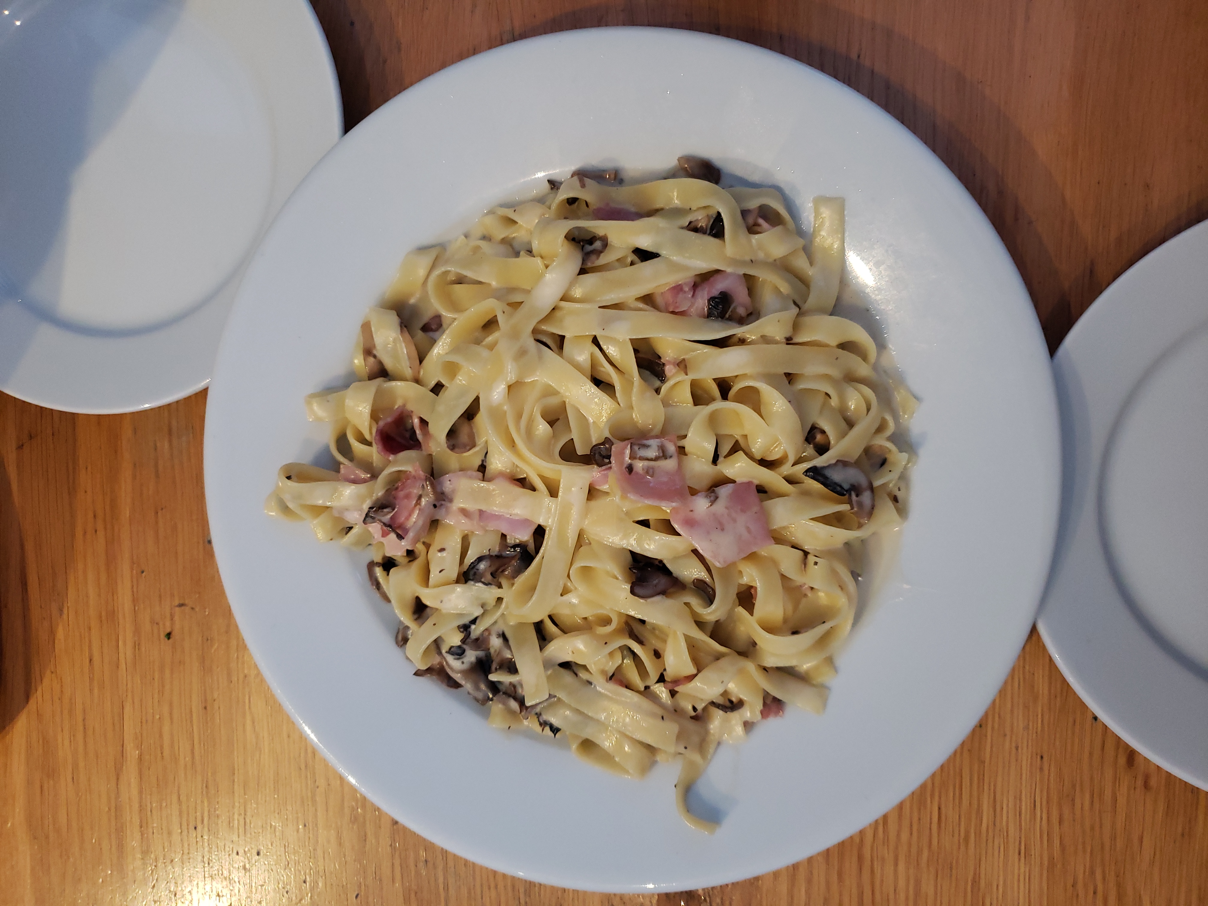 Tagliatelle with mushrooms and prosciutto served in a bowl