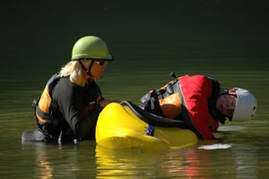A paddler in a kayak demonstrating the setup position for the C-to-C kayak roll
