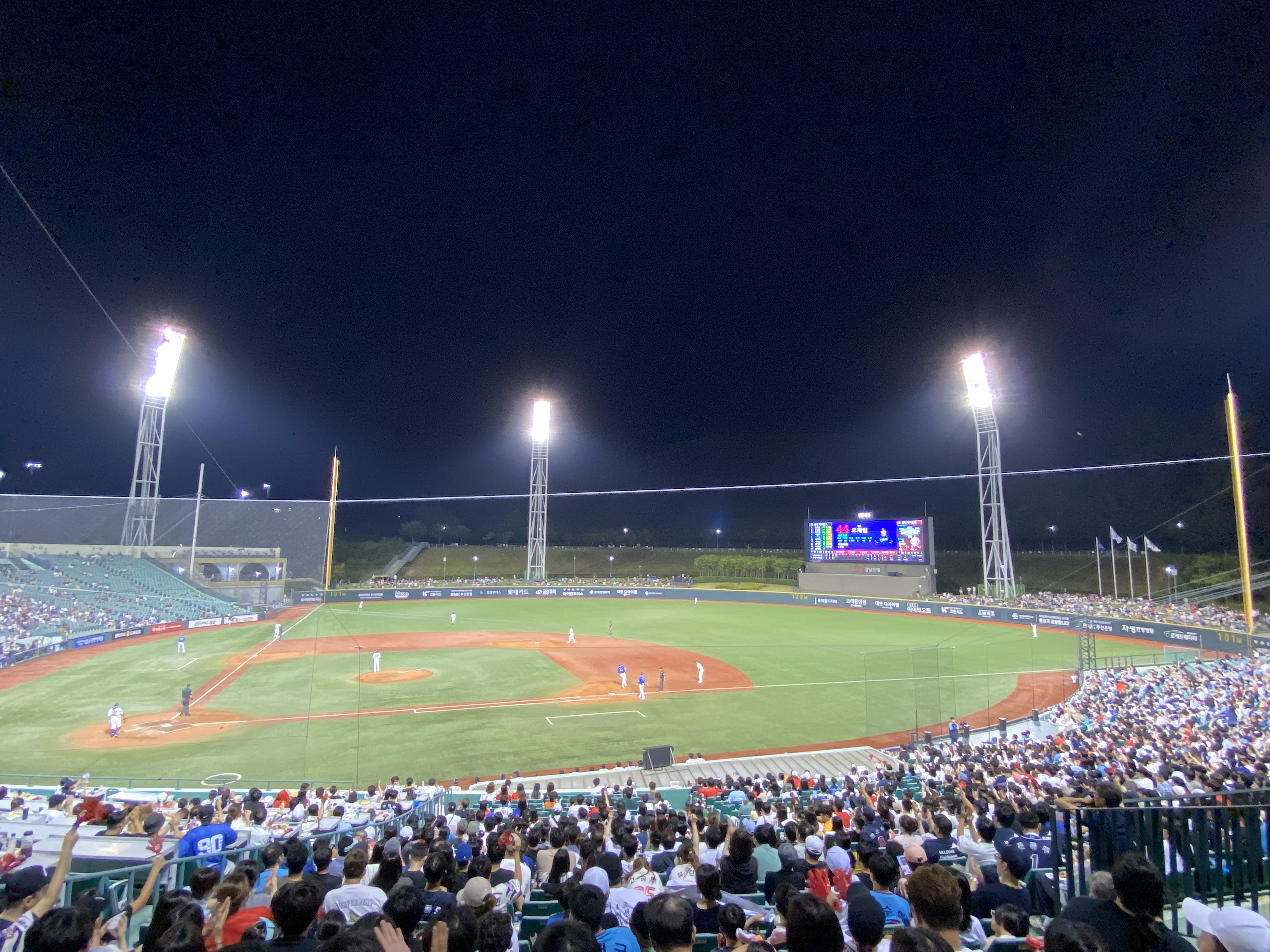 Baseball stadium with a green field under bright lights
