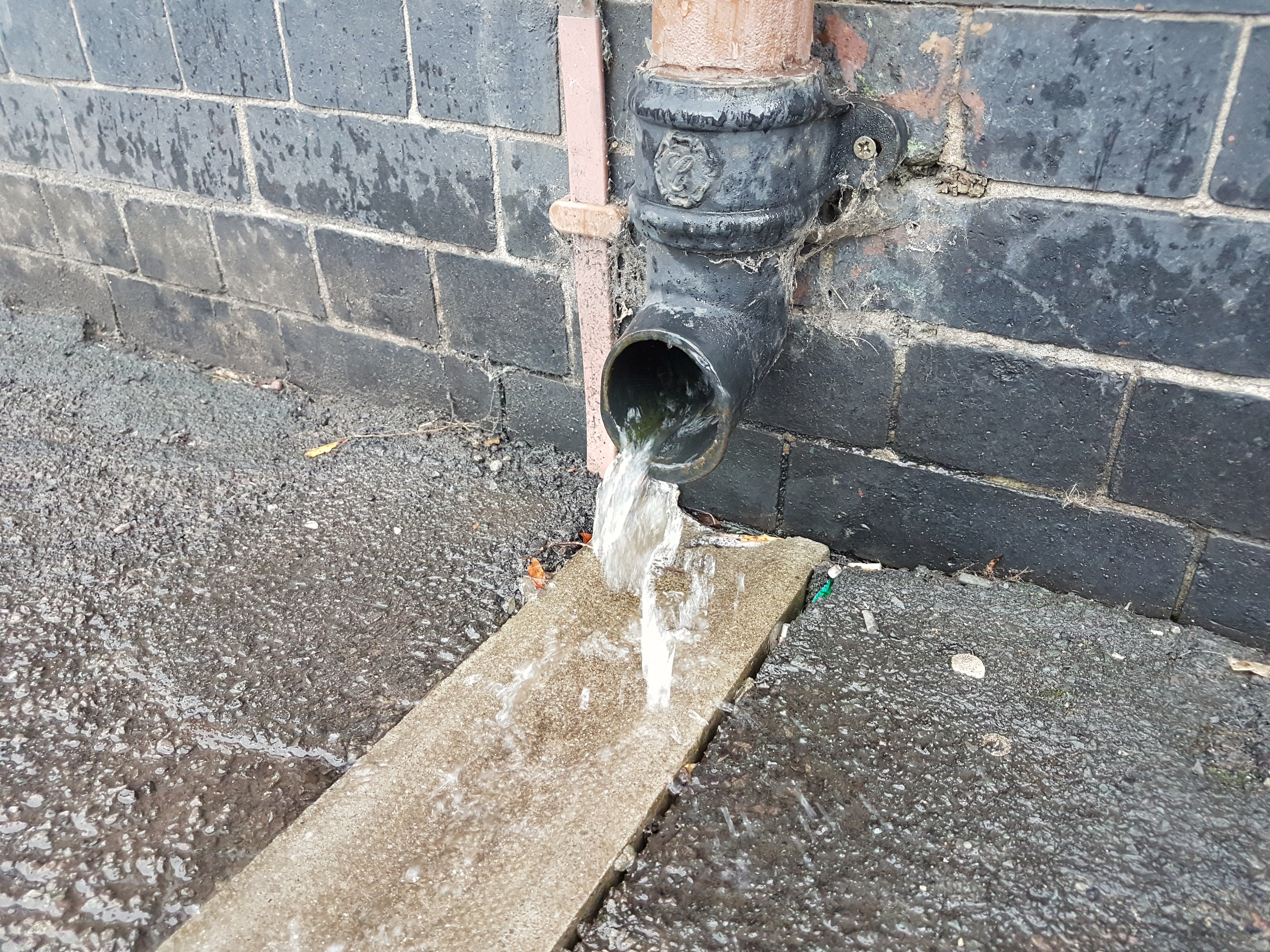 A downspout carrying water down the side of a building