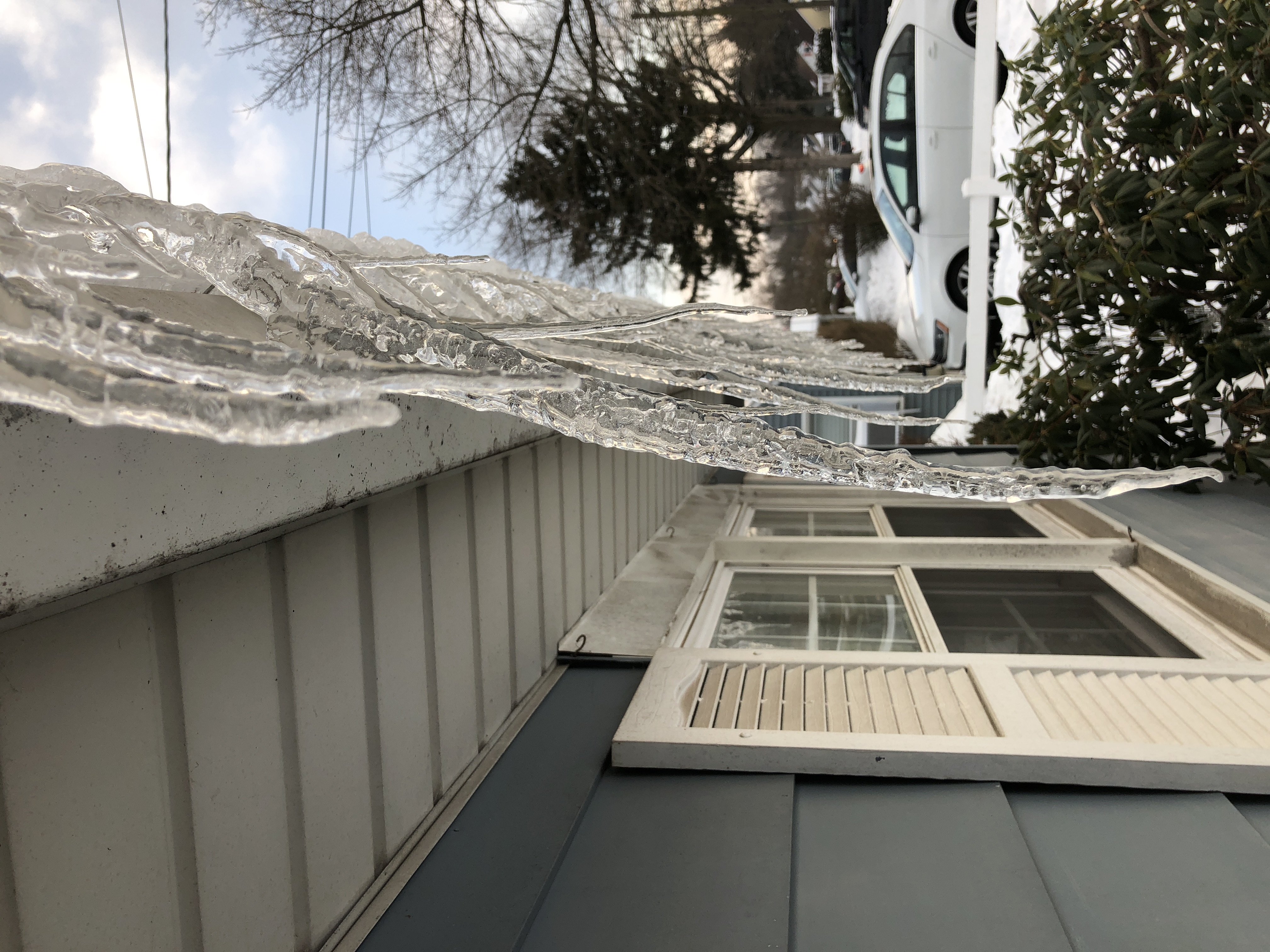Icicles hanging from a rain gutter on a house in winter