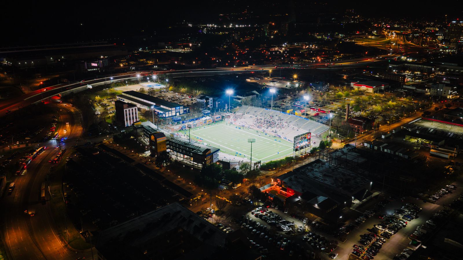 Aerial night view of a football stadium under bright floodlights
