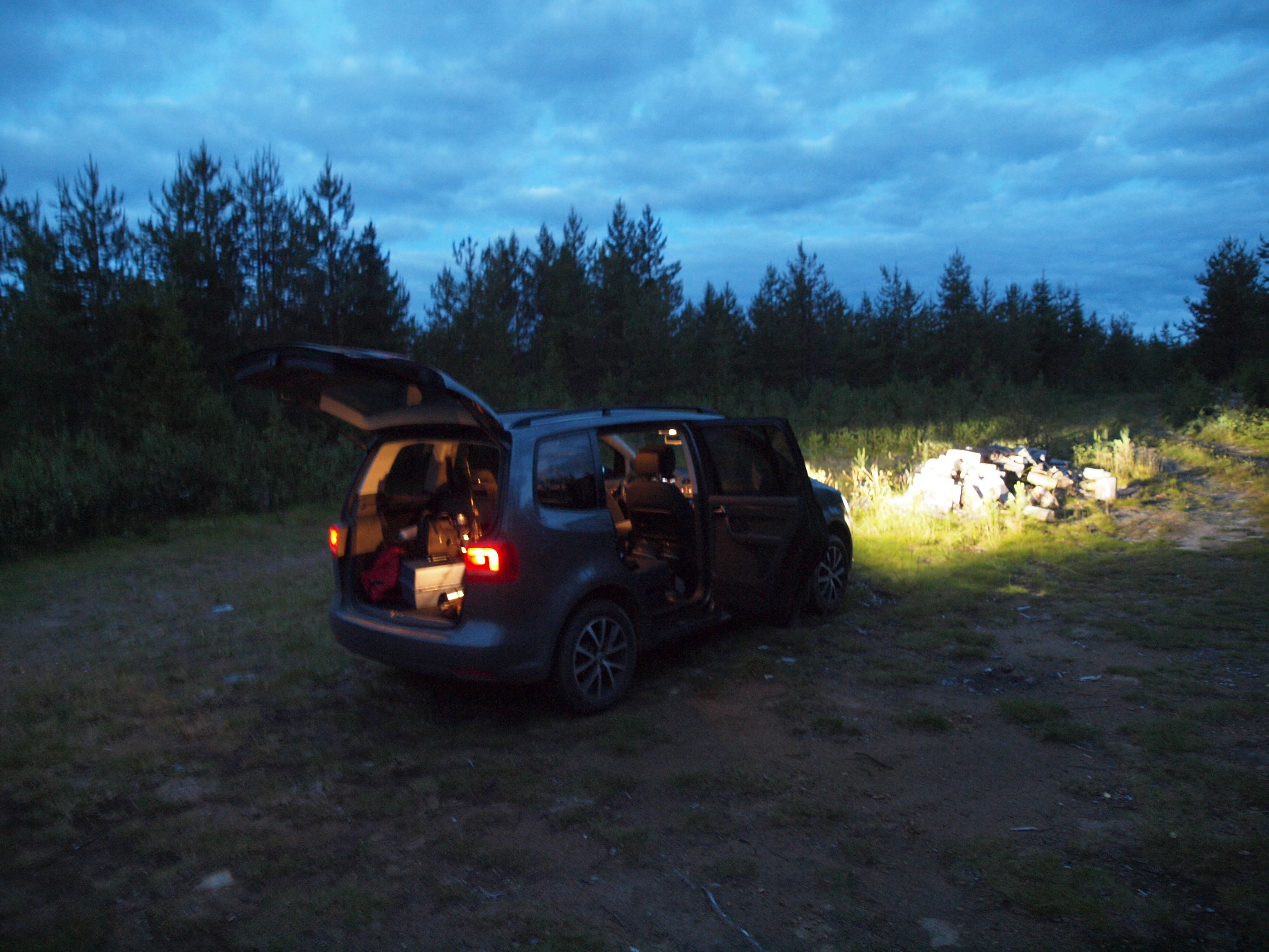 A car with headlights on at night in the wilderness