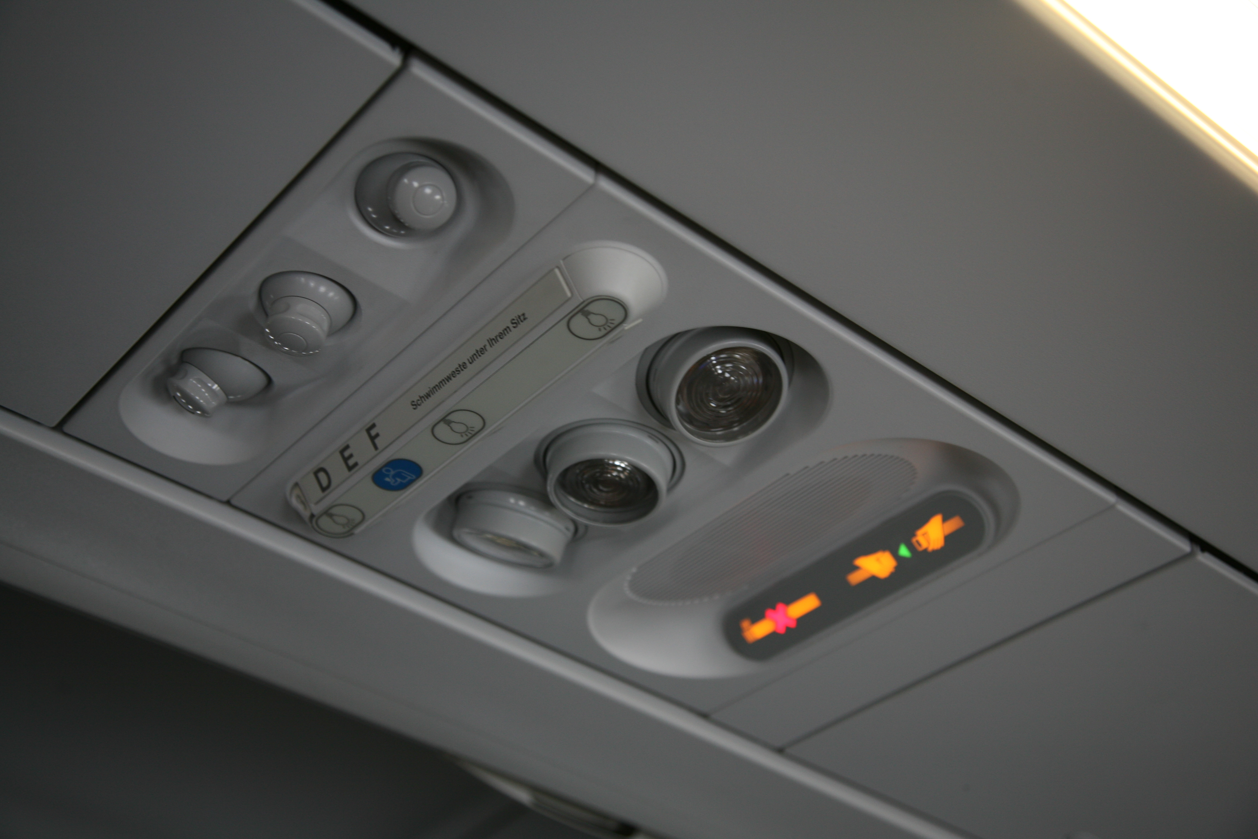 Overhead controls and passenger service panel inside an airplane cabin