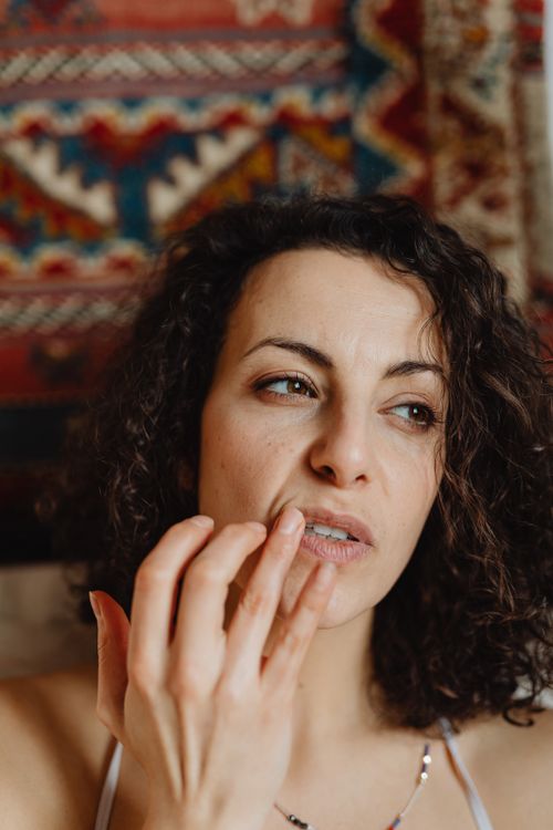 Close-up of a woman applying lip balm indoors