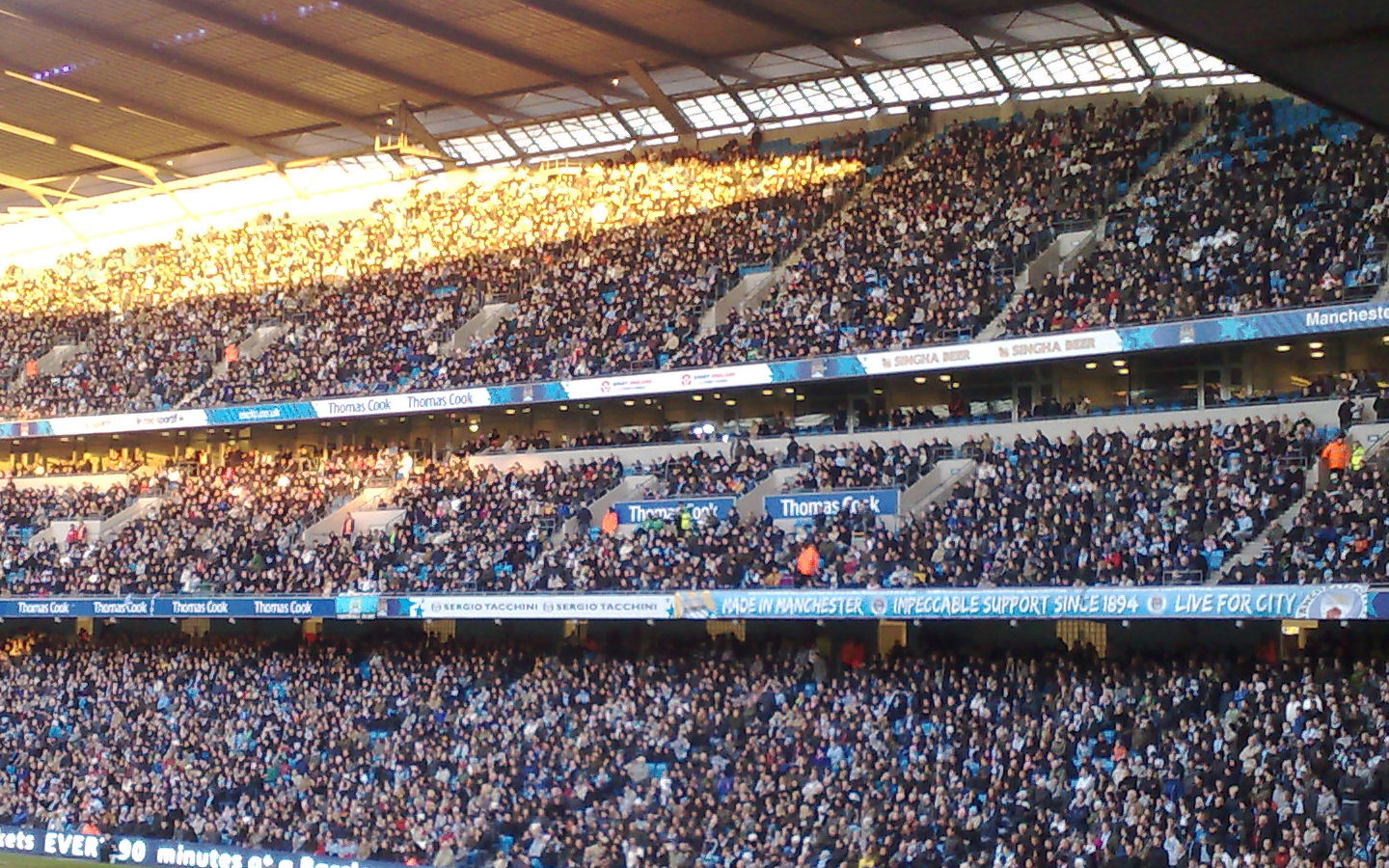 A crowd watches a match at the City of Manchester Stadium