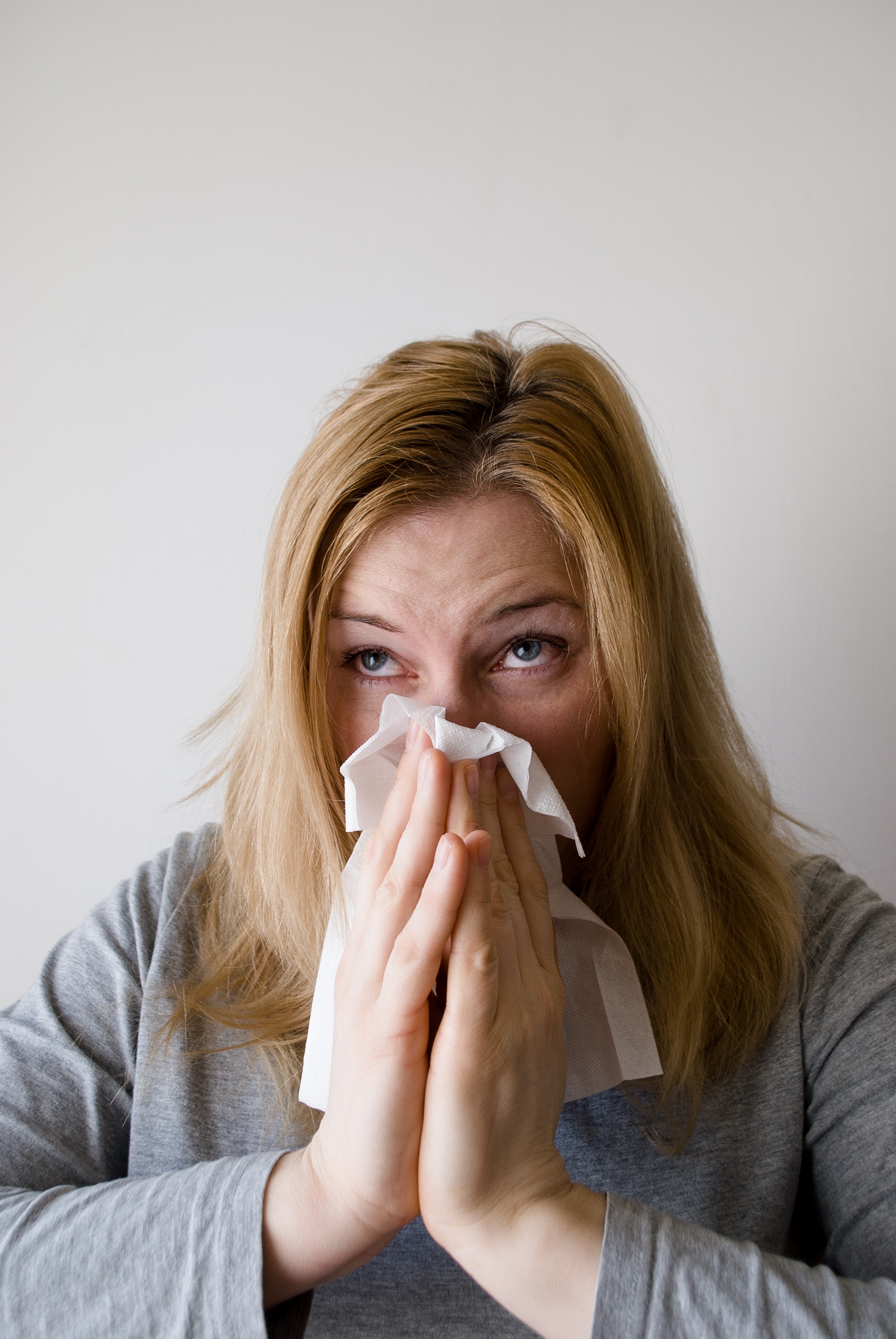 Woman blowing her nose into a tissue