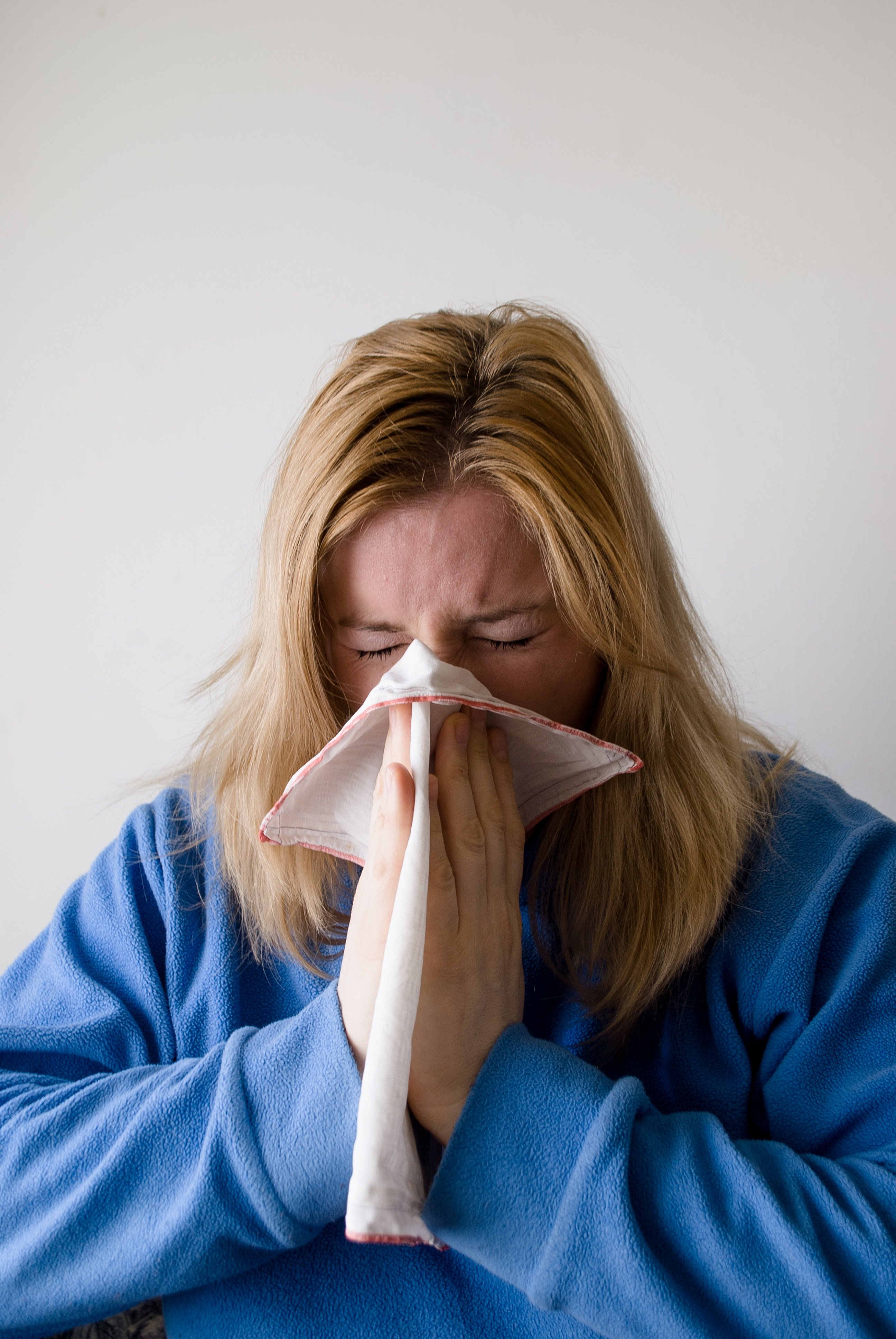 Woman in a fleece holding a handkerchief to her nose