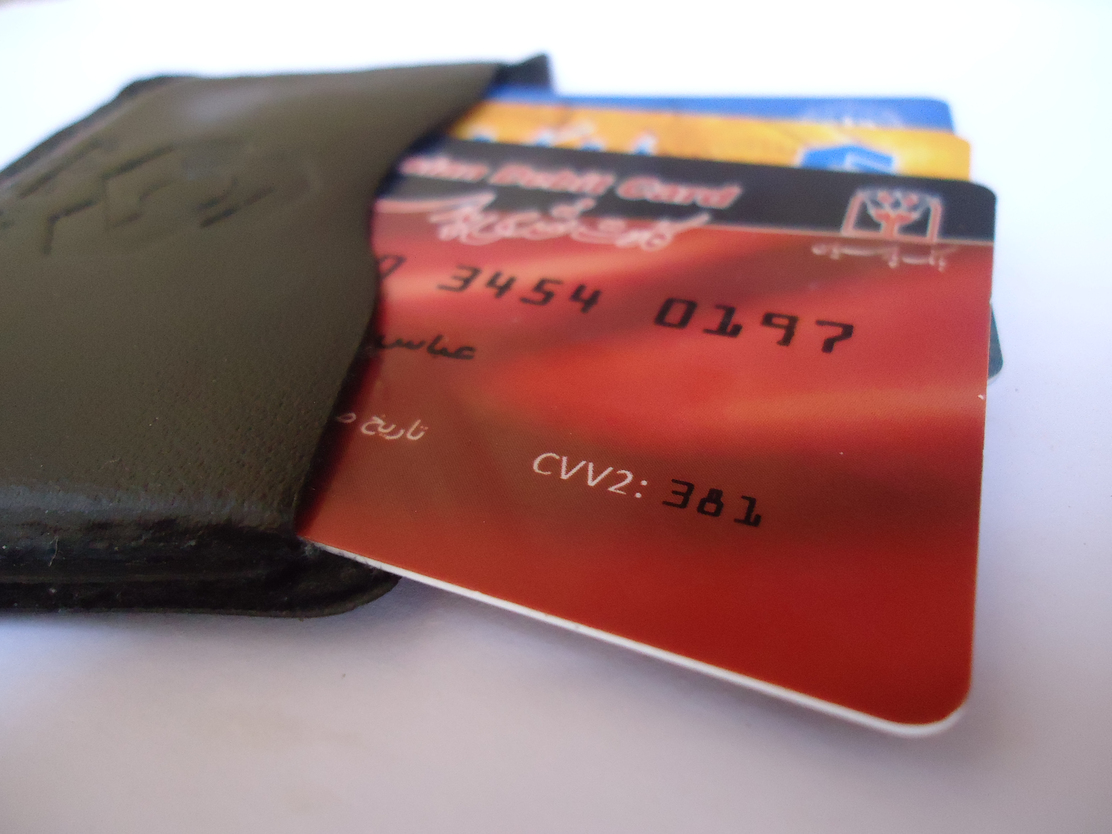 A debit card sliding out of a black card sleeve