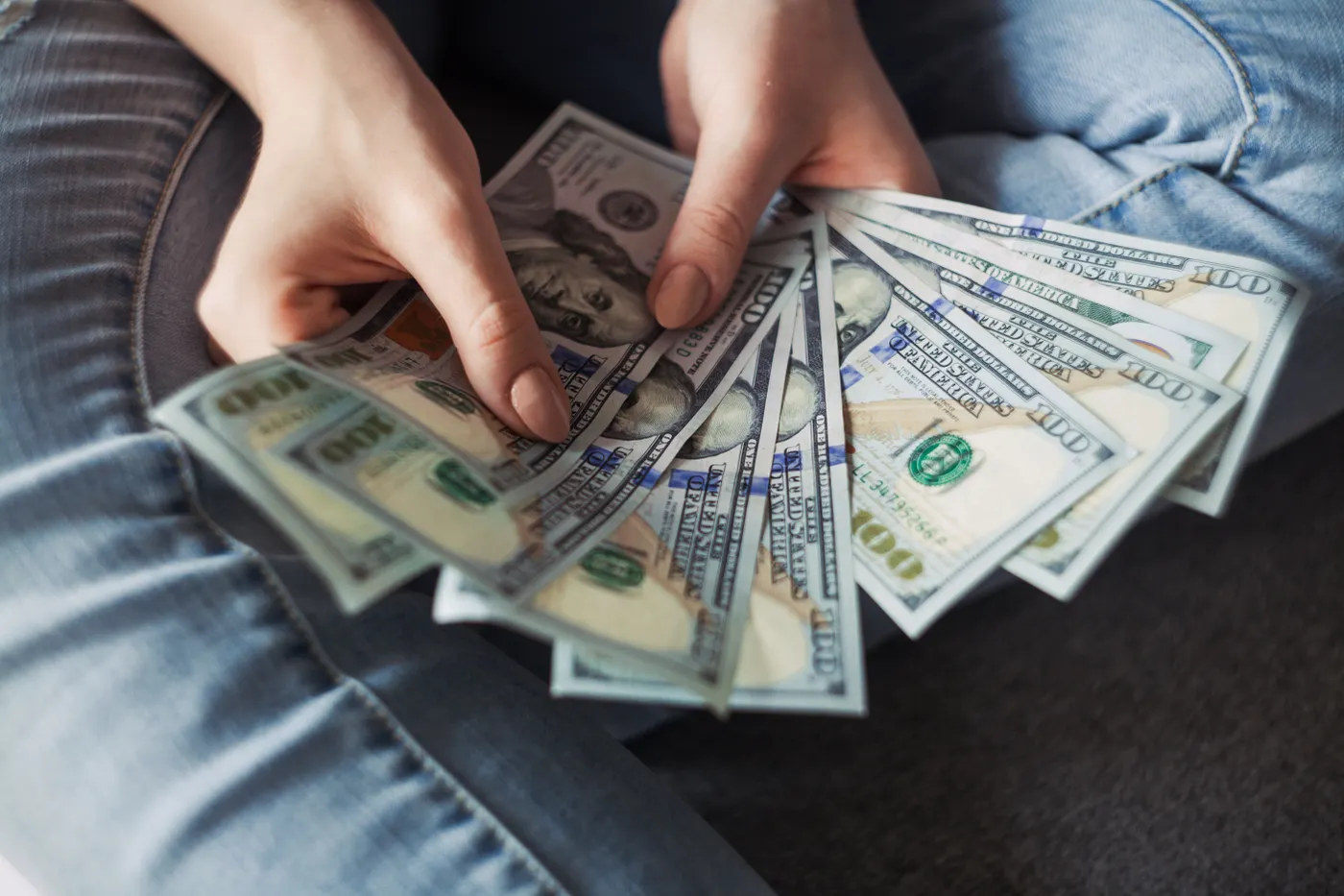 Hands fanning out one-hundred-dollar bills