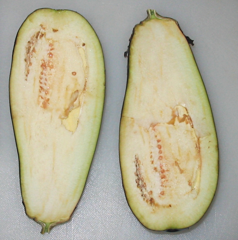 Sliced eggplant rounds ready for salting on a cutting board