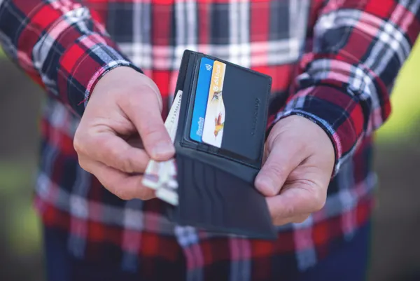 A person holding an open wallet with credit cards