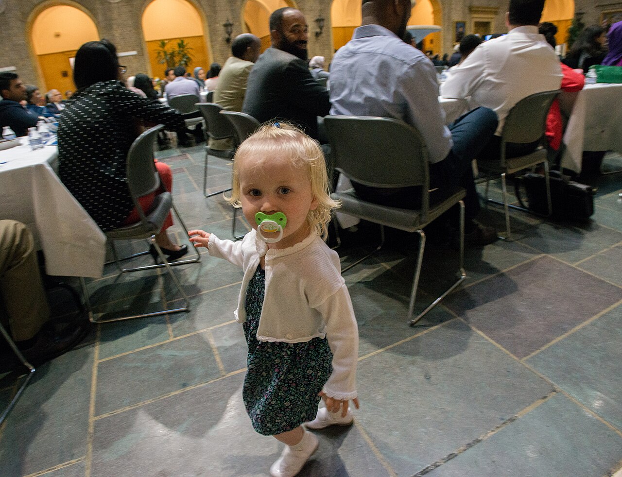 A 20-month-old toddler sits at a table during a family meal