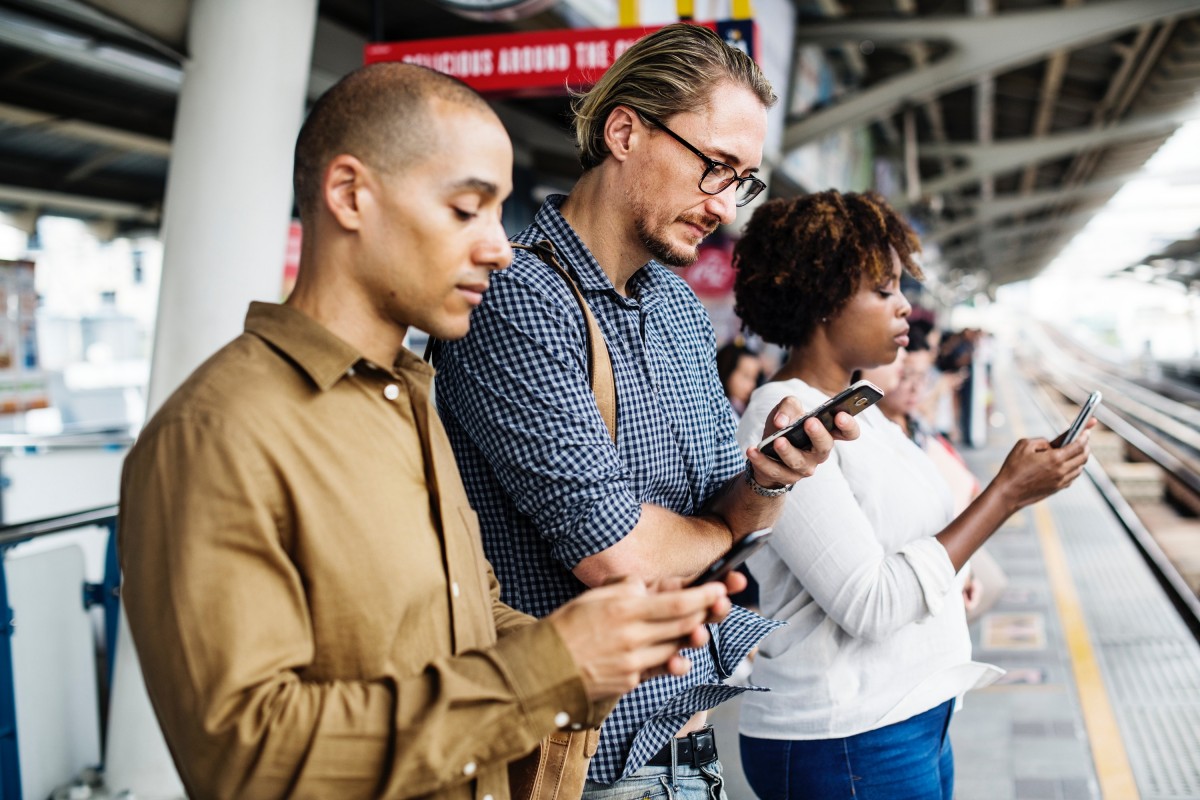 A person using a smartphone at a railway station