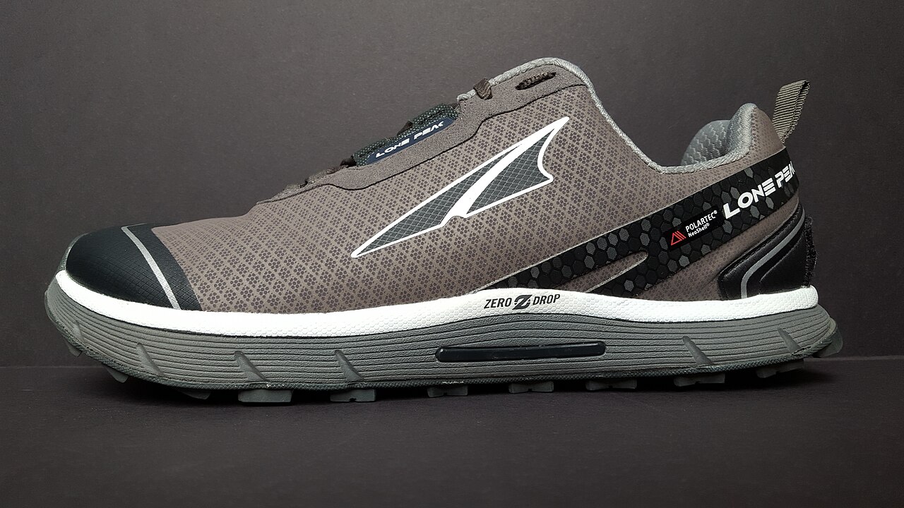 An Altra Lone Peak trail shoe shown from the side with its lugged outsole