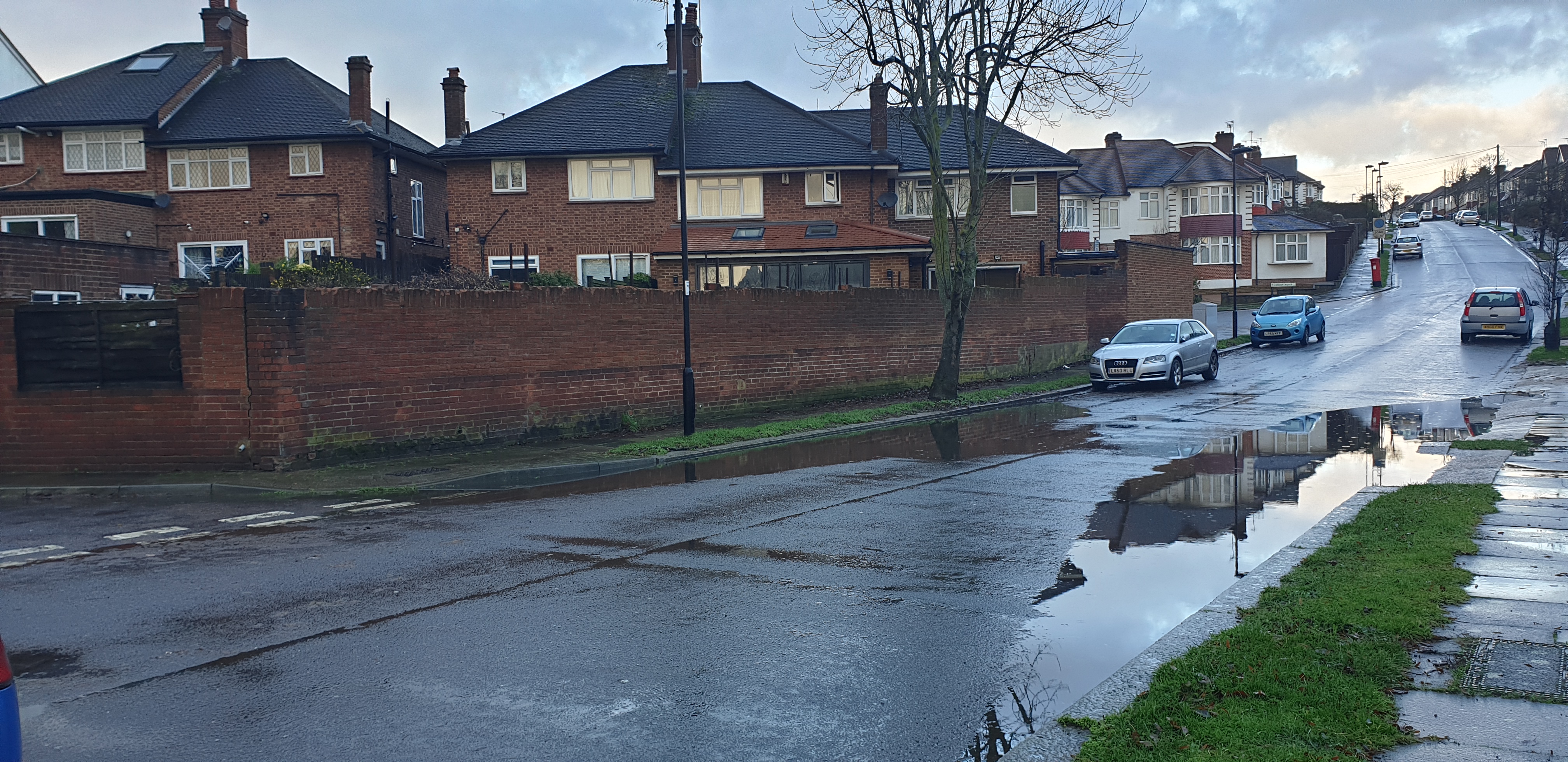 A residential street flooded with water after heavy rain