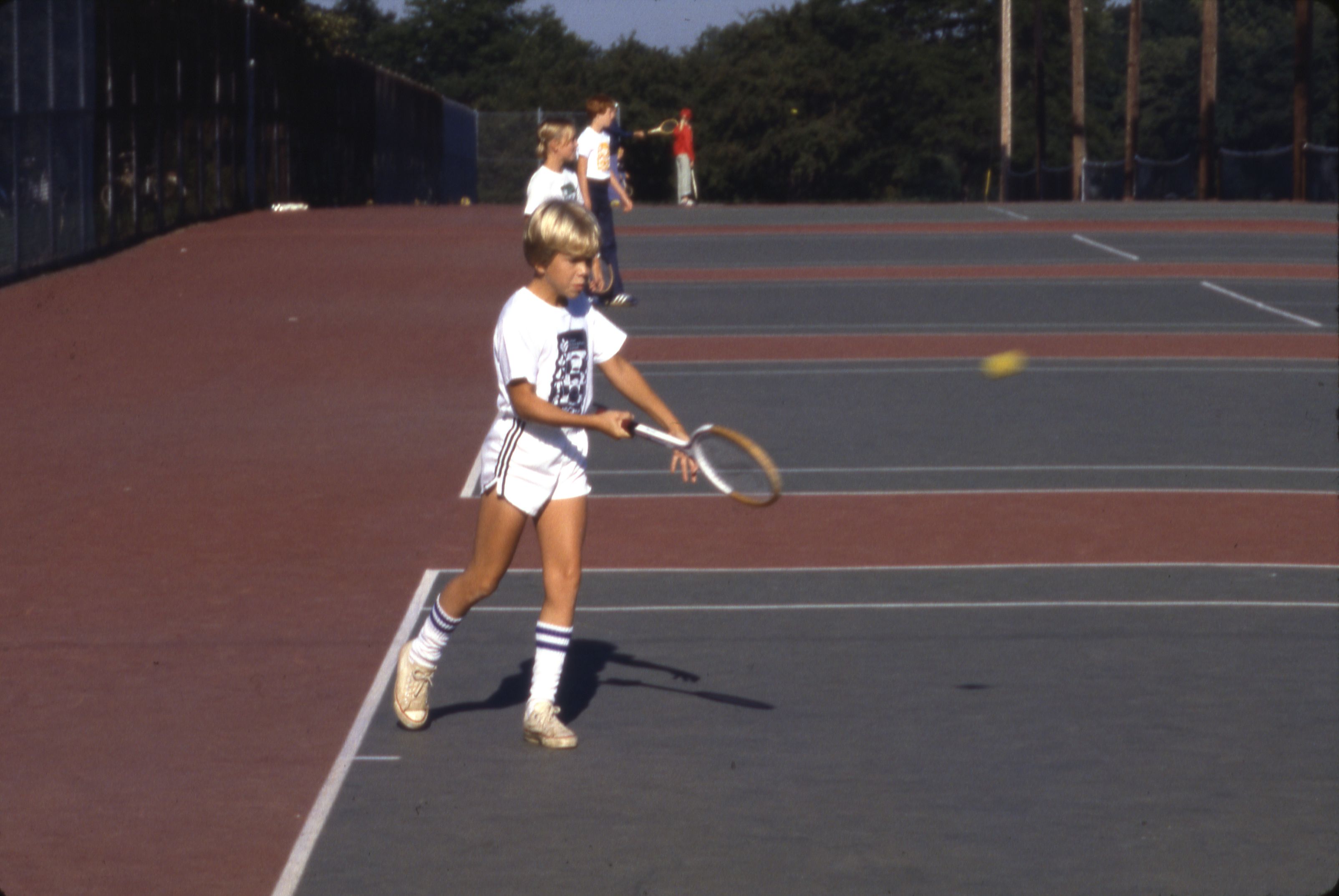A young tennis player on court with a racket