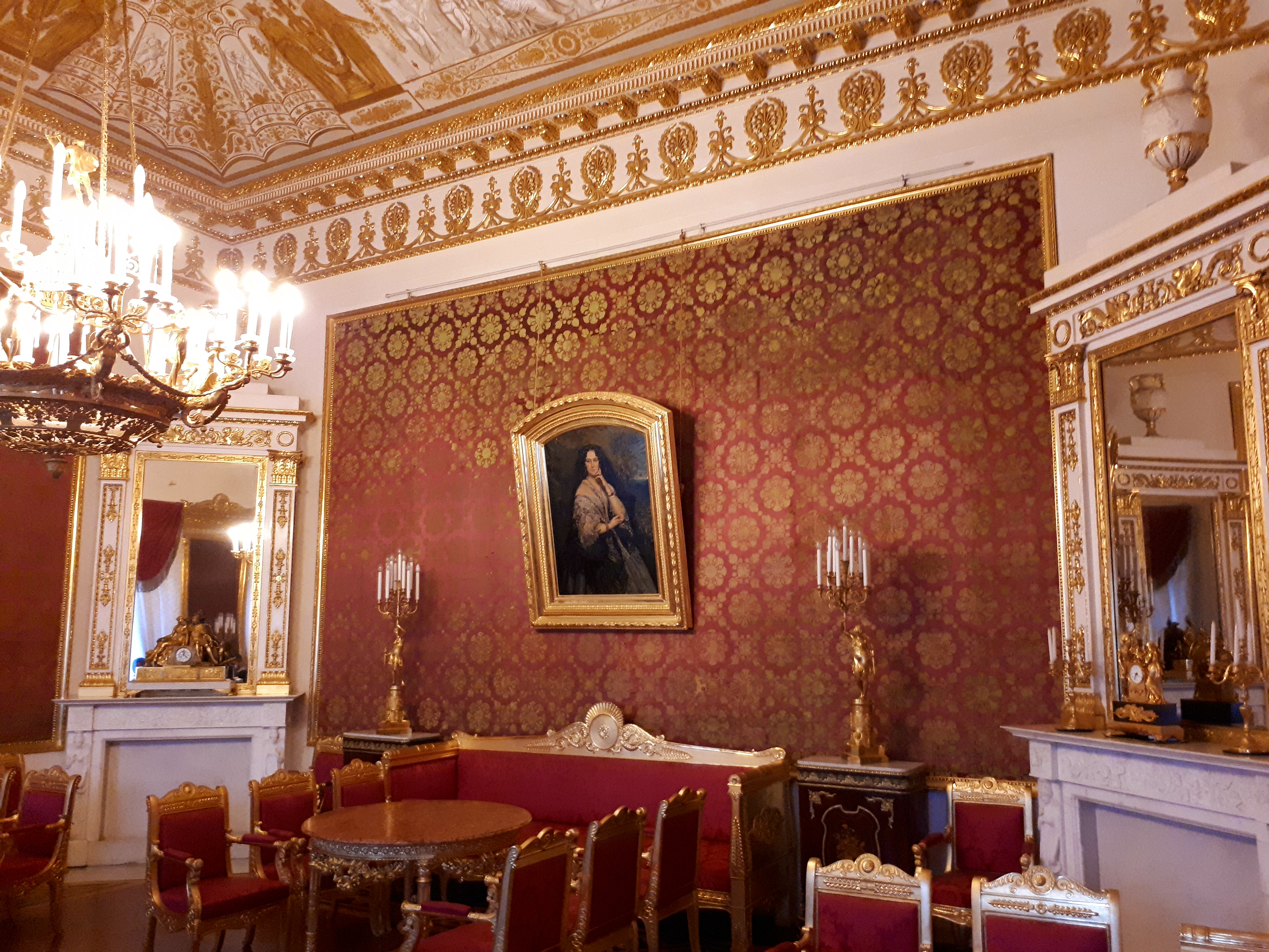 A red living room with classic furniture and a large mirror