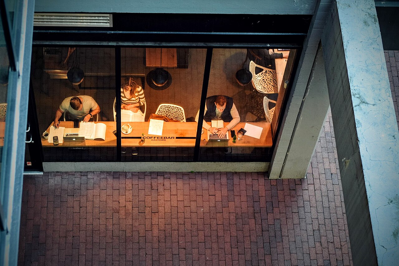 People working on laptops in a busy coffee shop