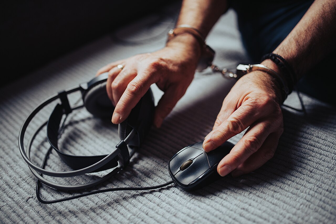 Headphones lying near a computer mouse on a soft surface