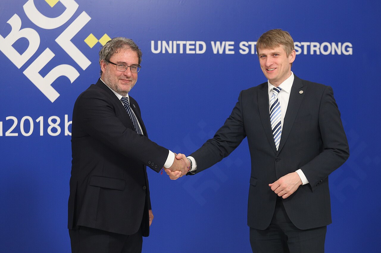 Two people shaking hands at a meeting