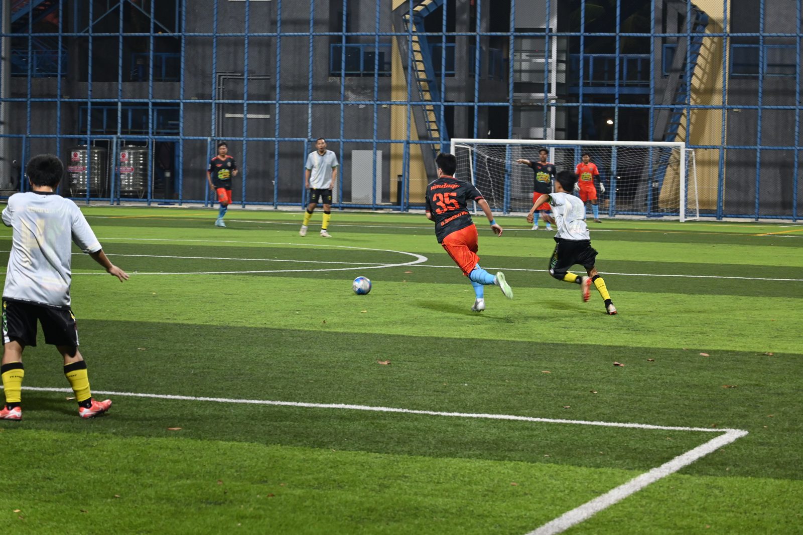 Players in action during a football match under the lights