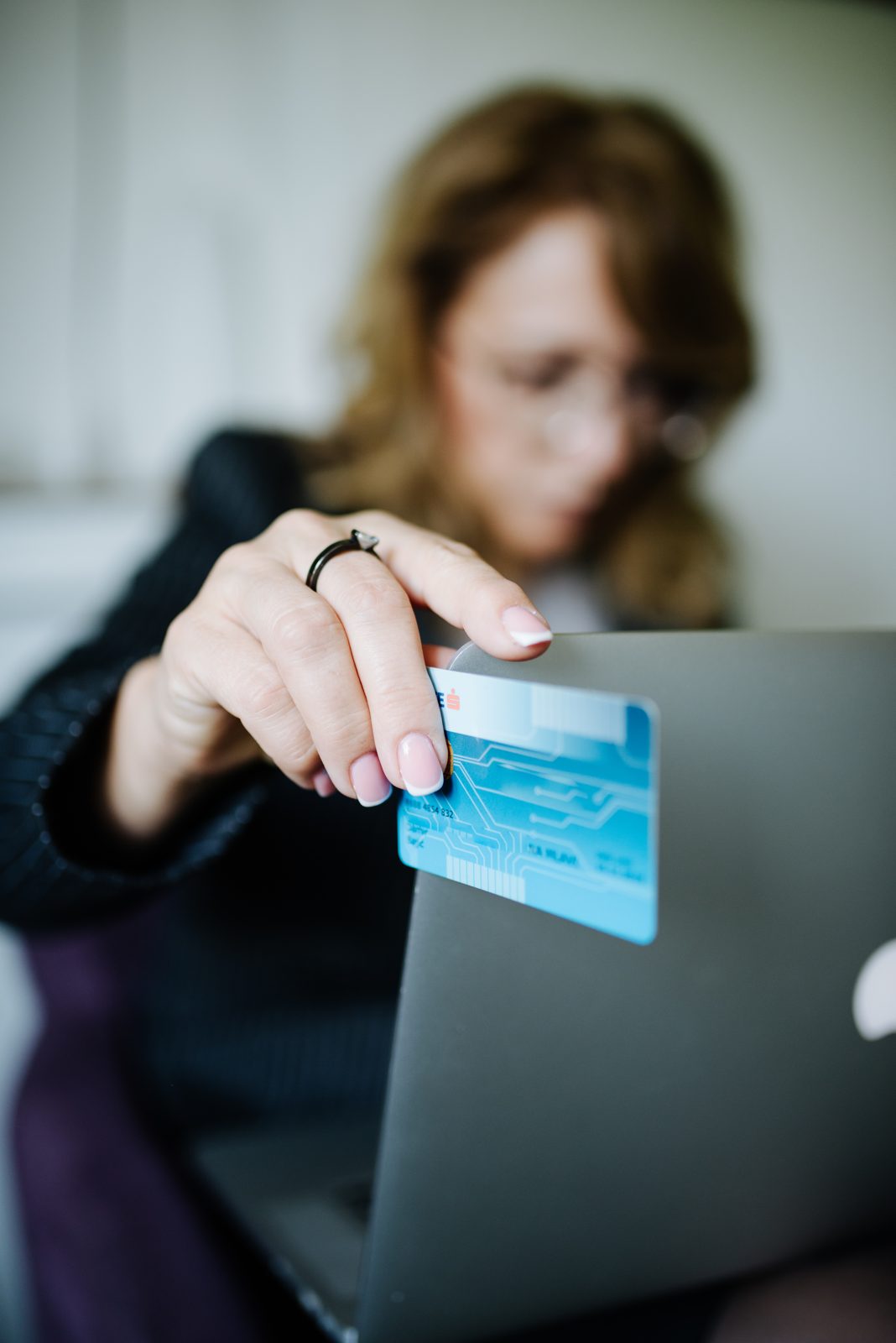 A person paying online with a credit card and a laptop