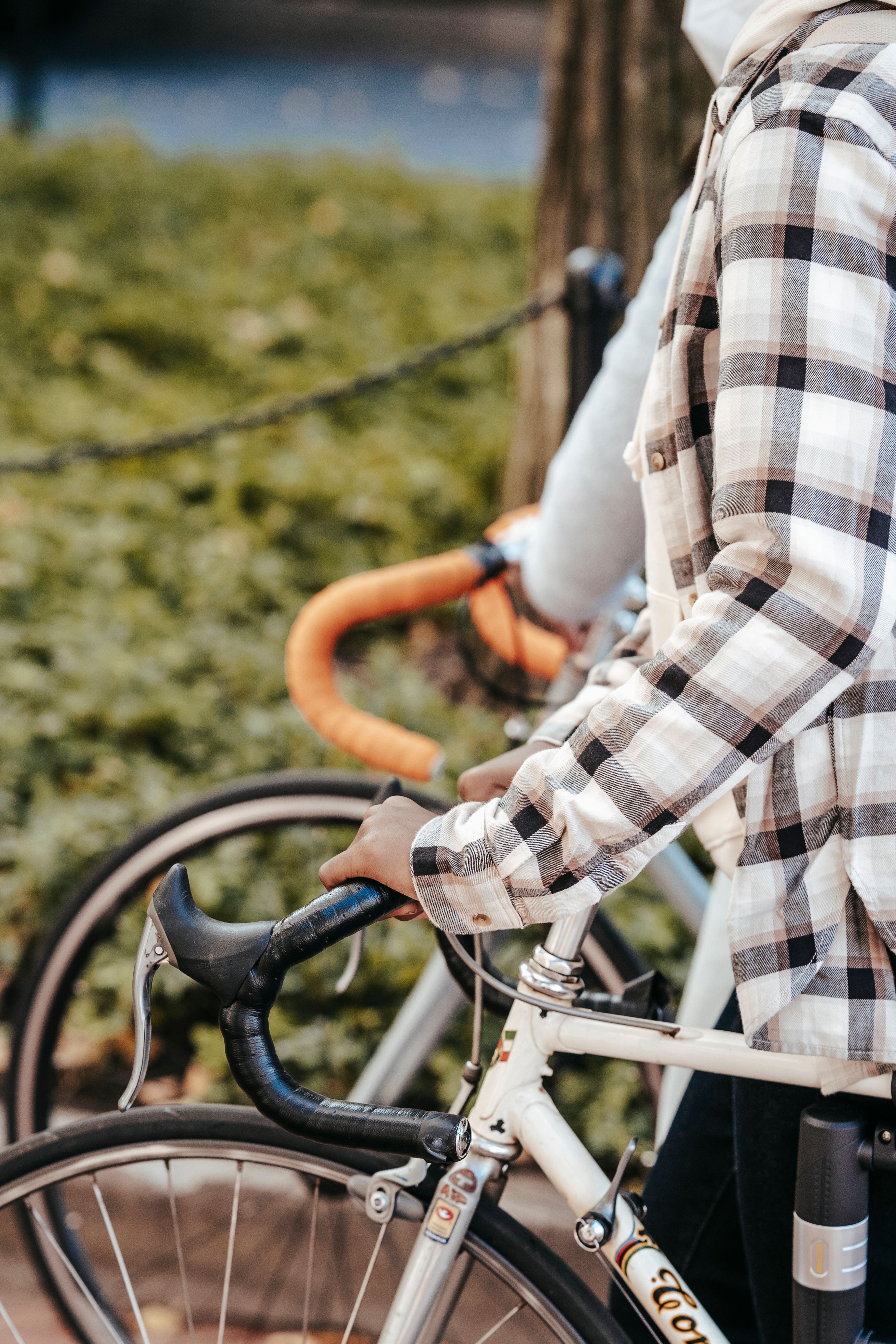 A cyclist riding a bicycle on a sidewalk, showing riding posture on a fitted bike