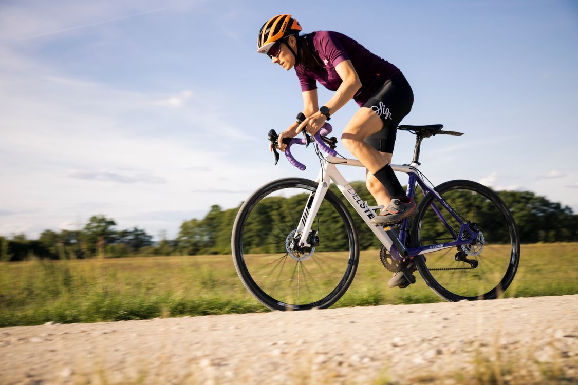 A cyclist riding a road bike on a sunny day in open countryside