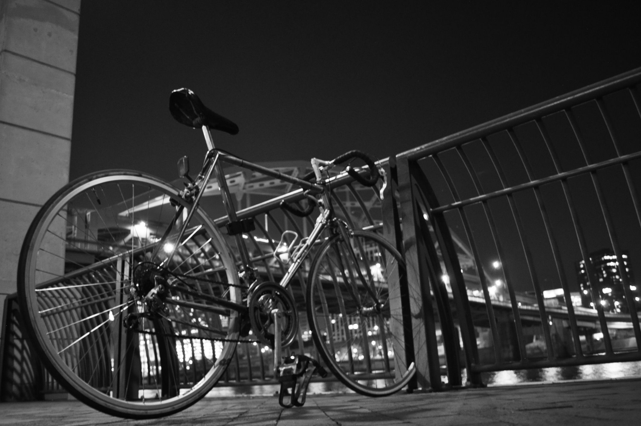 A bicycle parked on a city street with a cyclist nearby