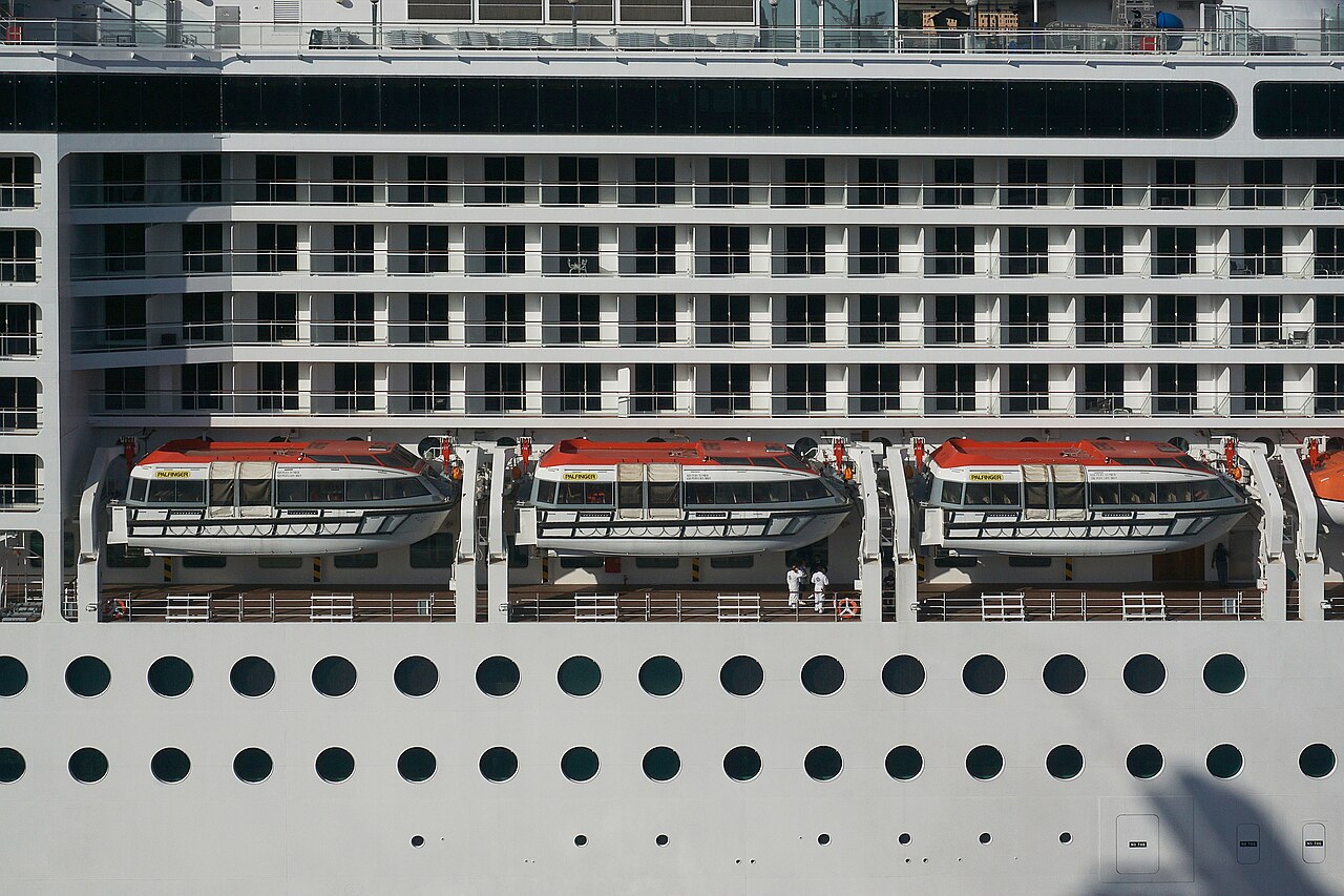 Lifeboats lined along the side of a cruise ship
