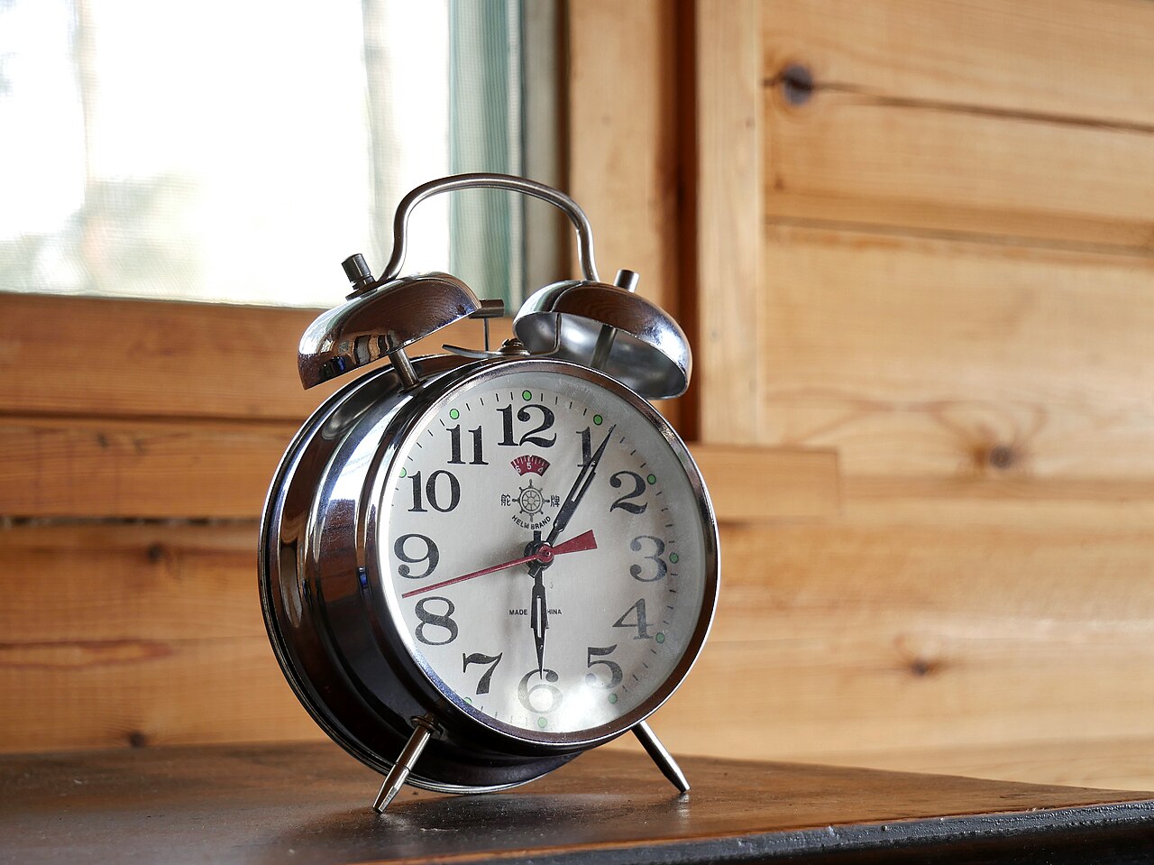 A classic alarm clock on a plain background