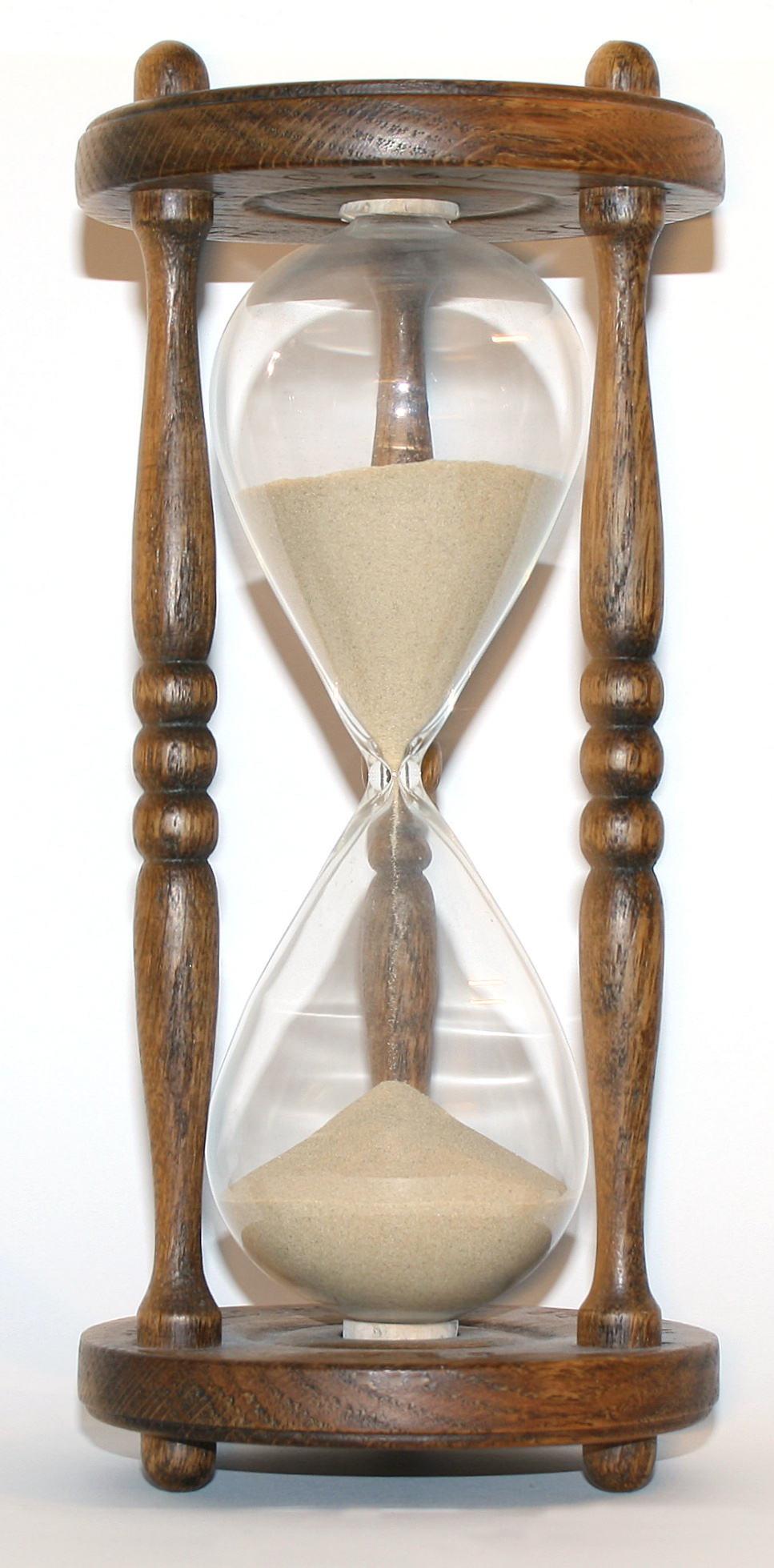 A wooden hourglass standing on a table