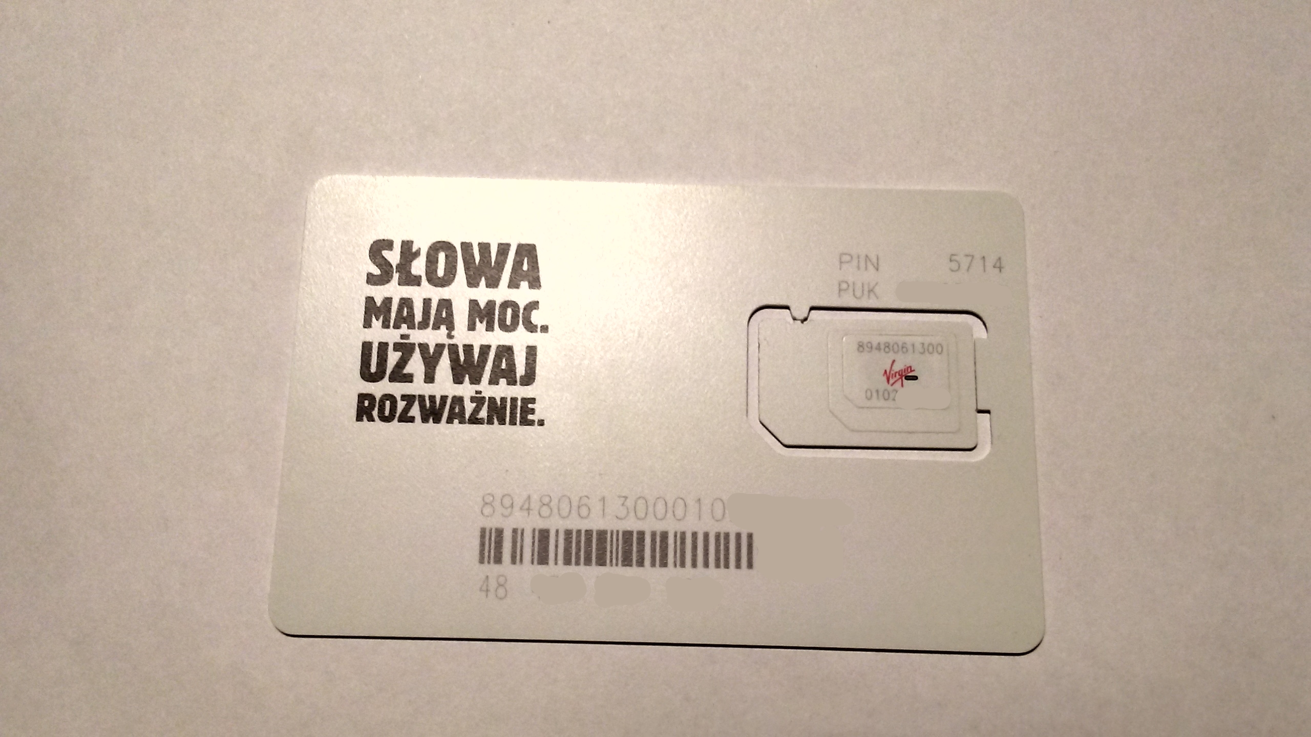 A physical SIM card held against a plain background