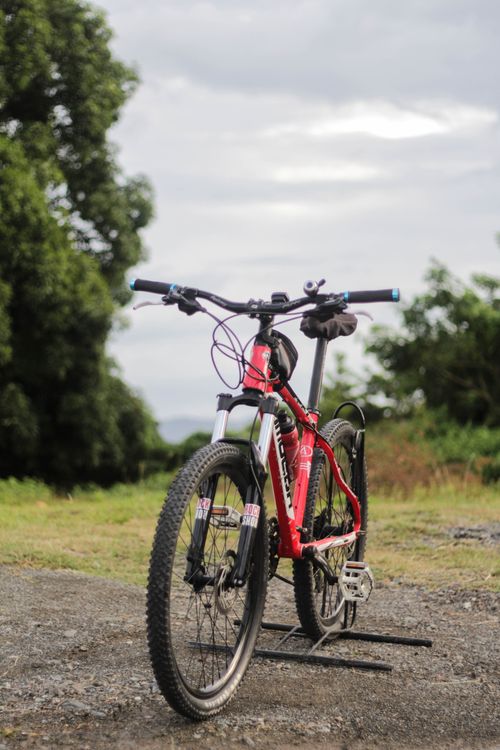A black and red full suspension mountain bike standing outdoors
