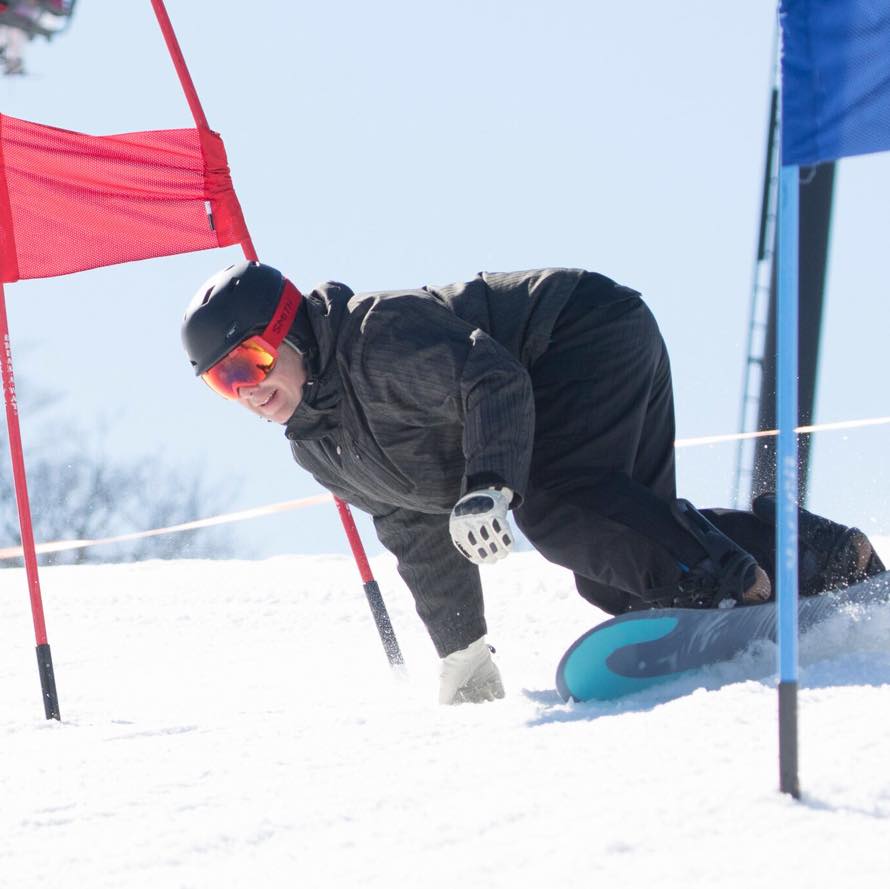 A snowboarder riding on a snowy slope, wearing a helmet and winter gear