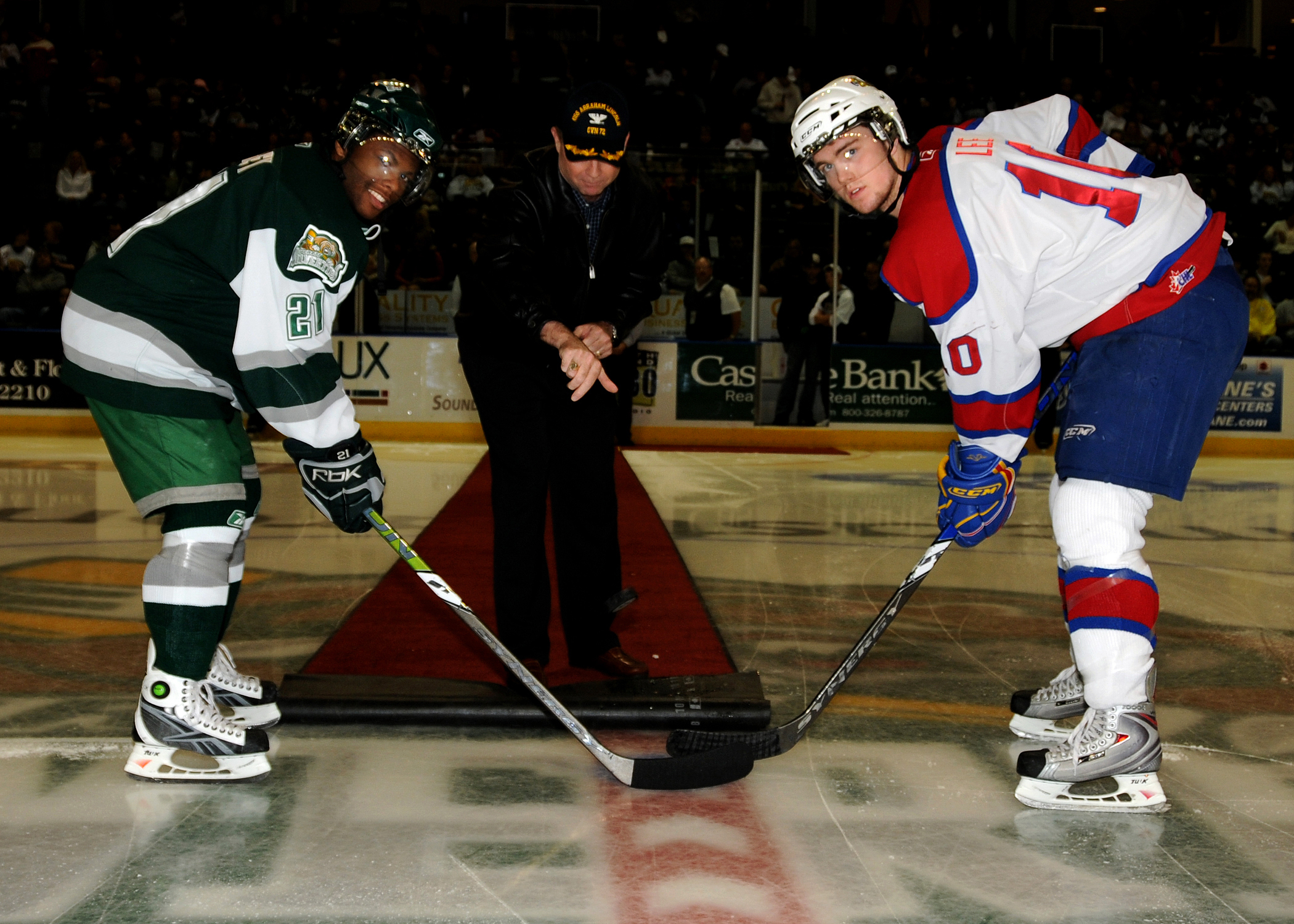An official drops the puck to start play in an ice hockey game