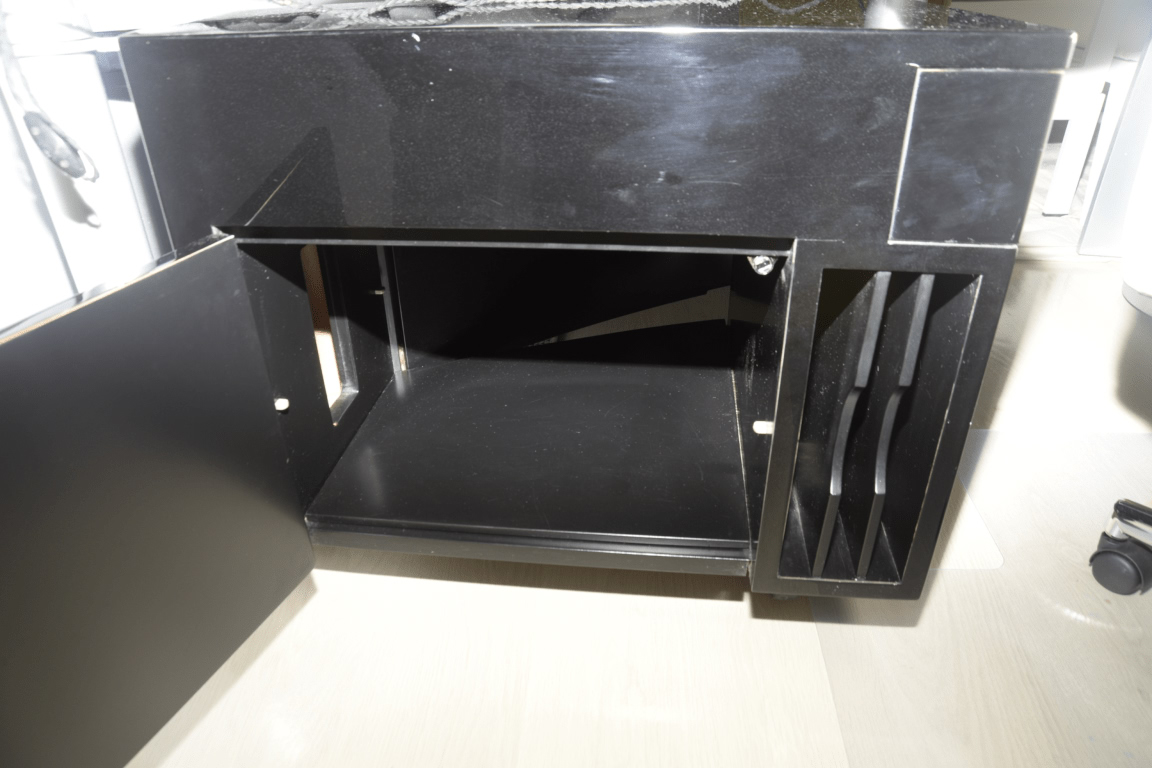 An empty black desk cabinet with its door open