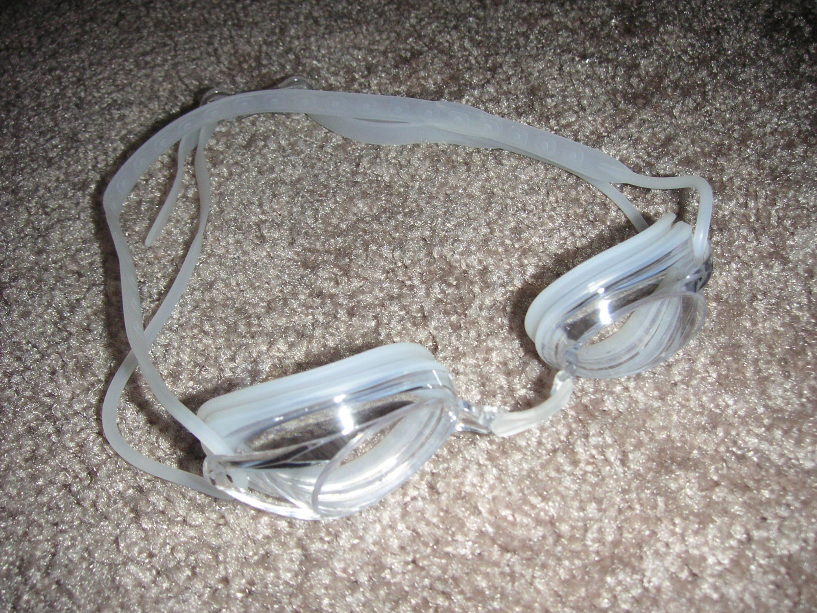 A pair of swimming goggles resting on a flat surface, lenses clear and dry