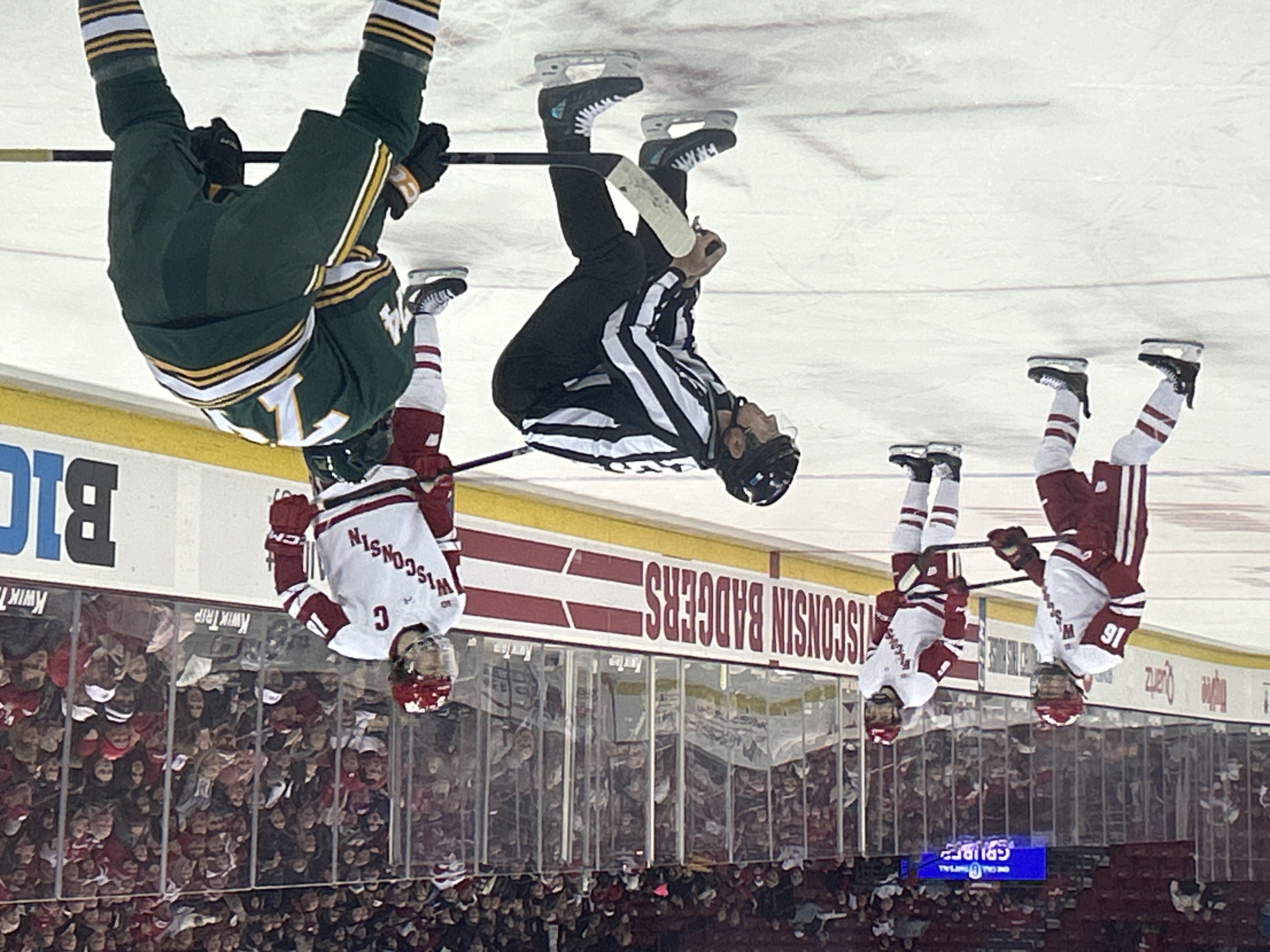Ice hockey players chase the puck during a game