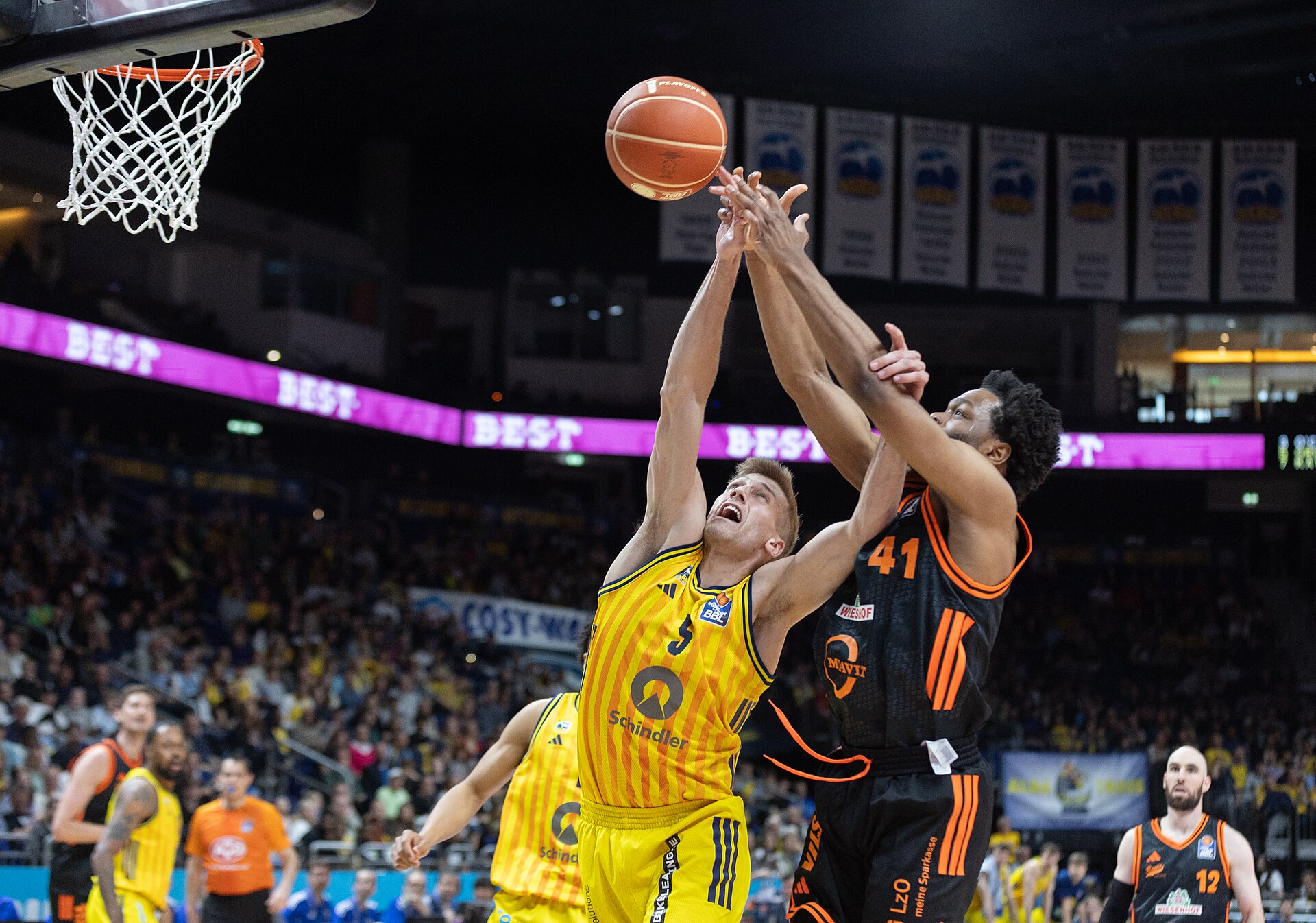 Basketball players fight for the ball under the basket